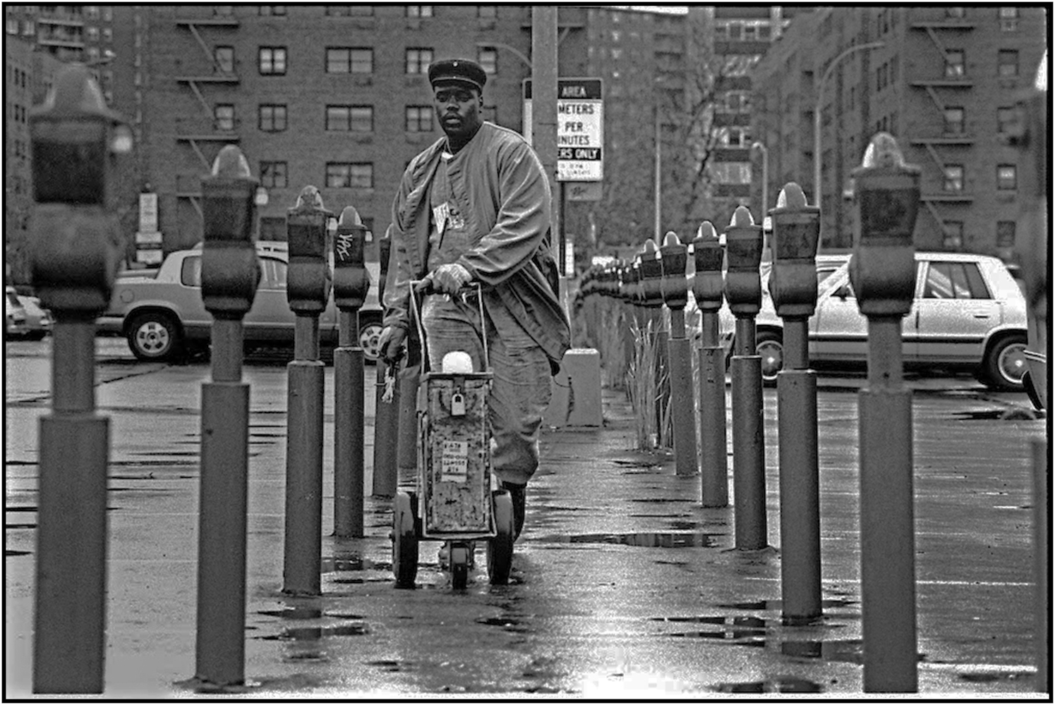   Keith Rhem, a parking meter service worker, collects quarters in a Queens municipal parking lot. 1990.  