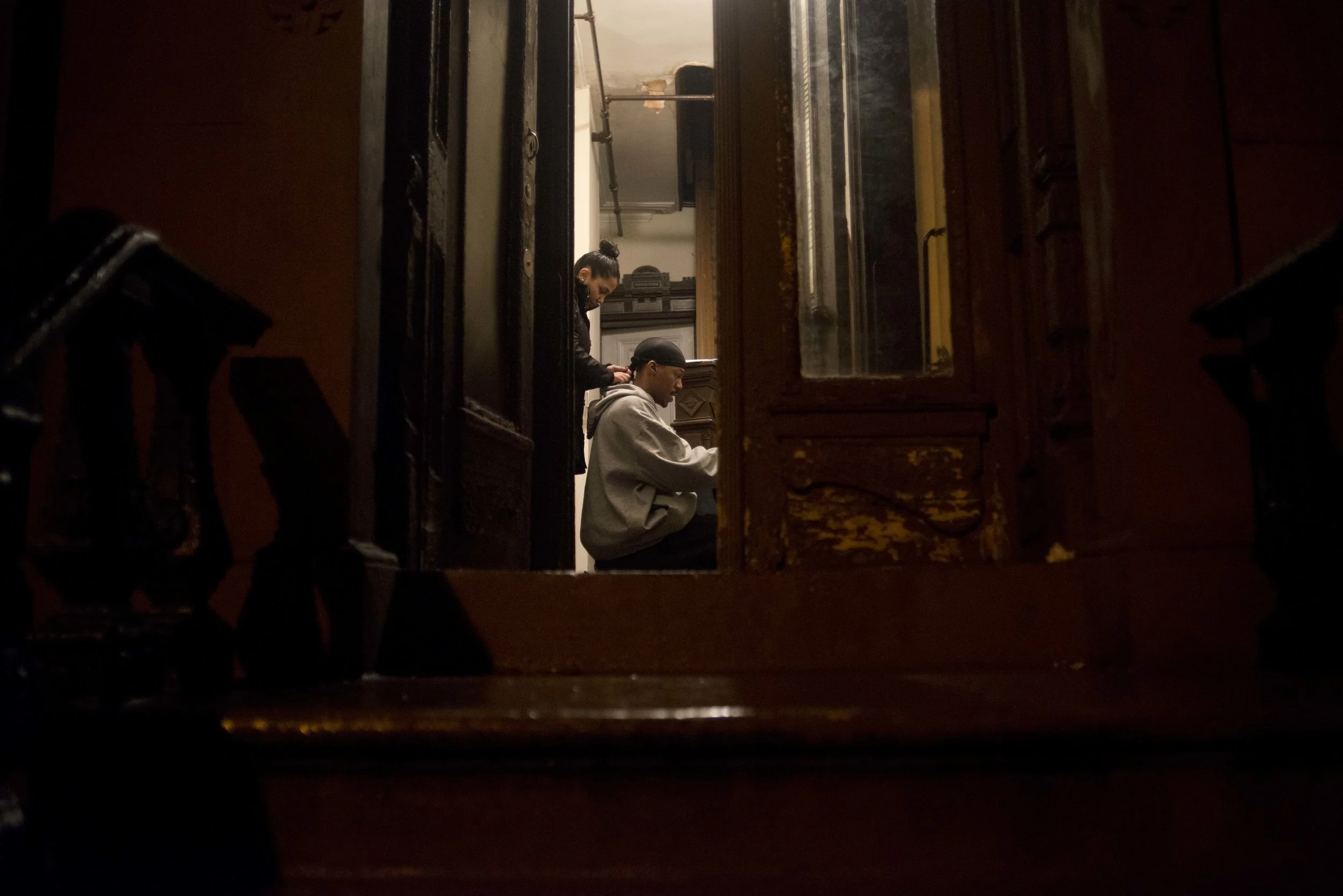 Before heading to work, Ferrin Bujan, 24, takes a moment to braid the hair of Sakeem Nelbett, her boyfriend. The couple met at Brooklyn Community Arts and Media High School where Ms. Bujan teaches. Mr. Nelbett now works at a high school in Bushwisk.