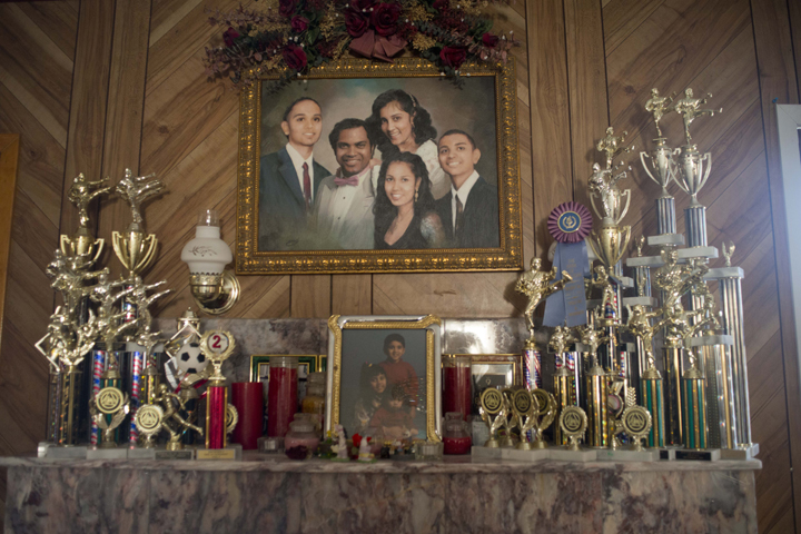 A family portrait of the Bujan family hangs above the mantle in Ms. Bujan's parents house in Queens, NY. The mantle is covered with martial arts trophies Ms. Bujan and her two brothers have won over the years.