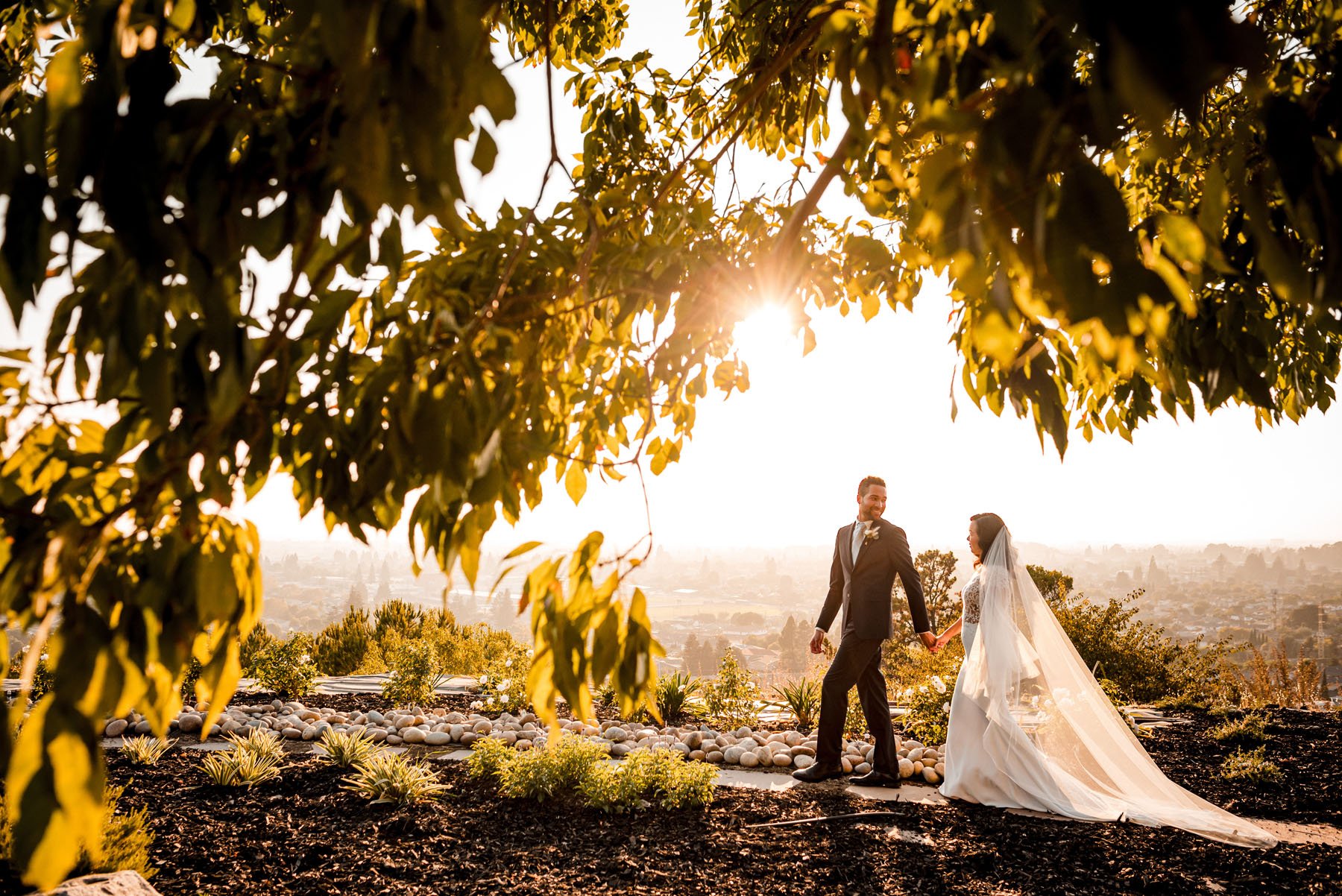 A bride and groom walk together during sunset at their bay area wedding