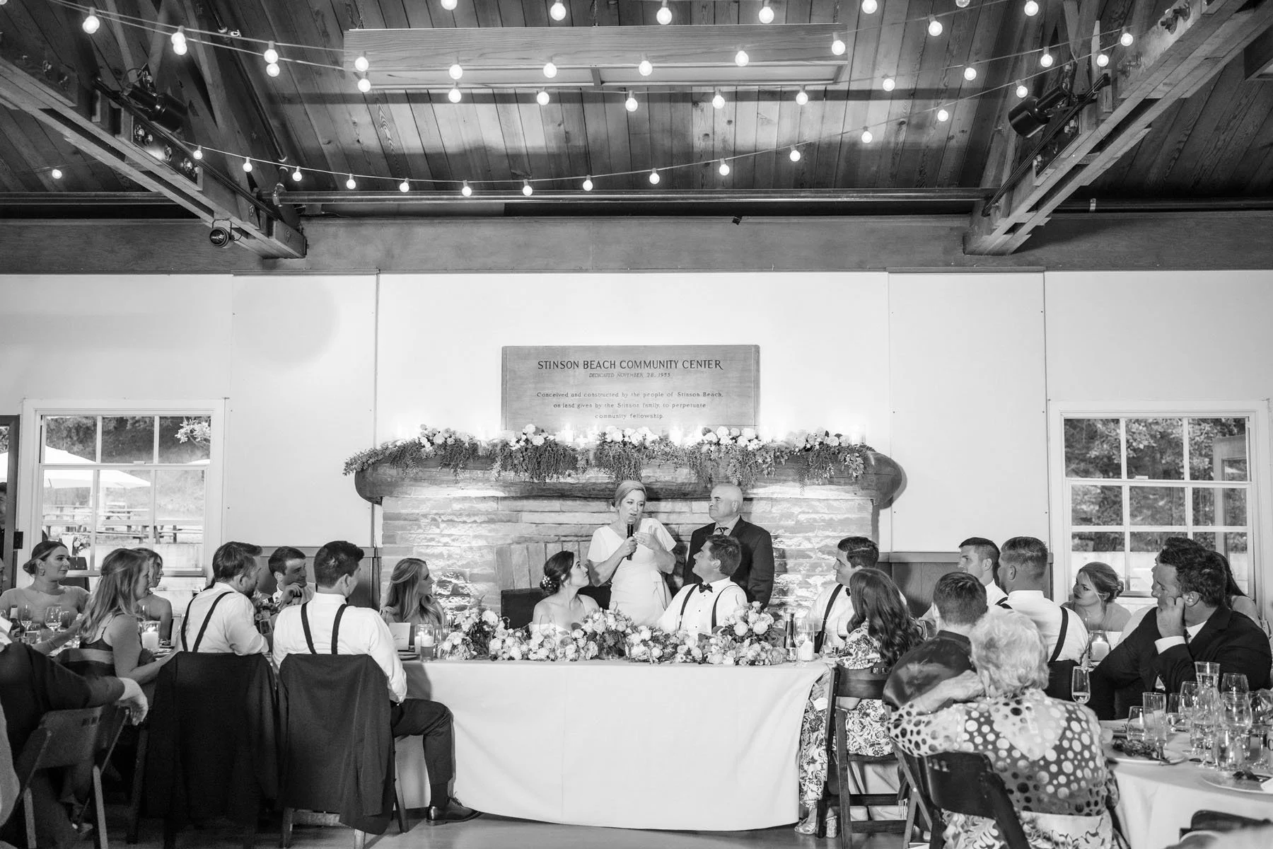 Bride and Groom listen to their wedding speeches at their reception at the Stinson Beach Community Center.