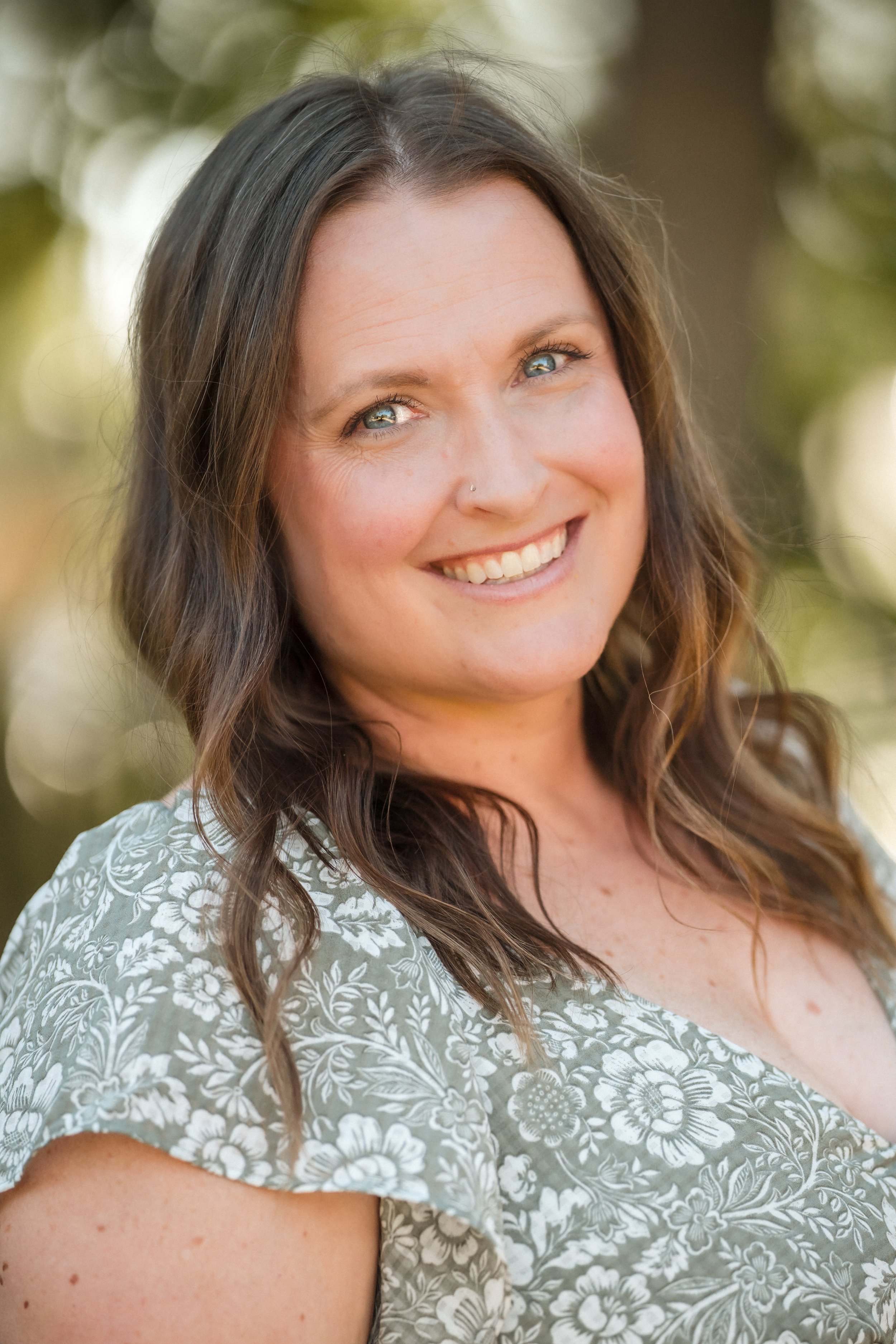 Sacramento Wedding photographer Katie Moeller of Katherine Nicole Photography smiles at the camera in a green floral dress