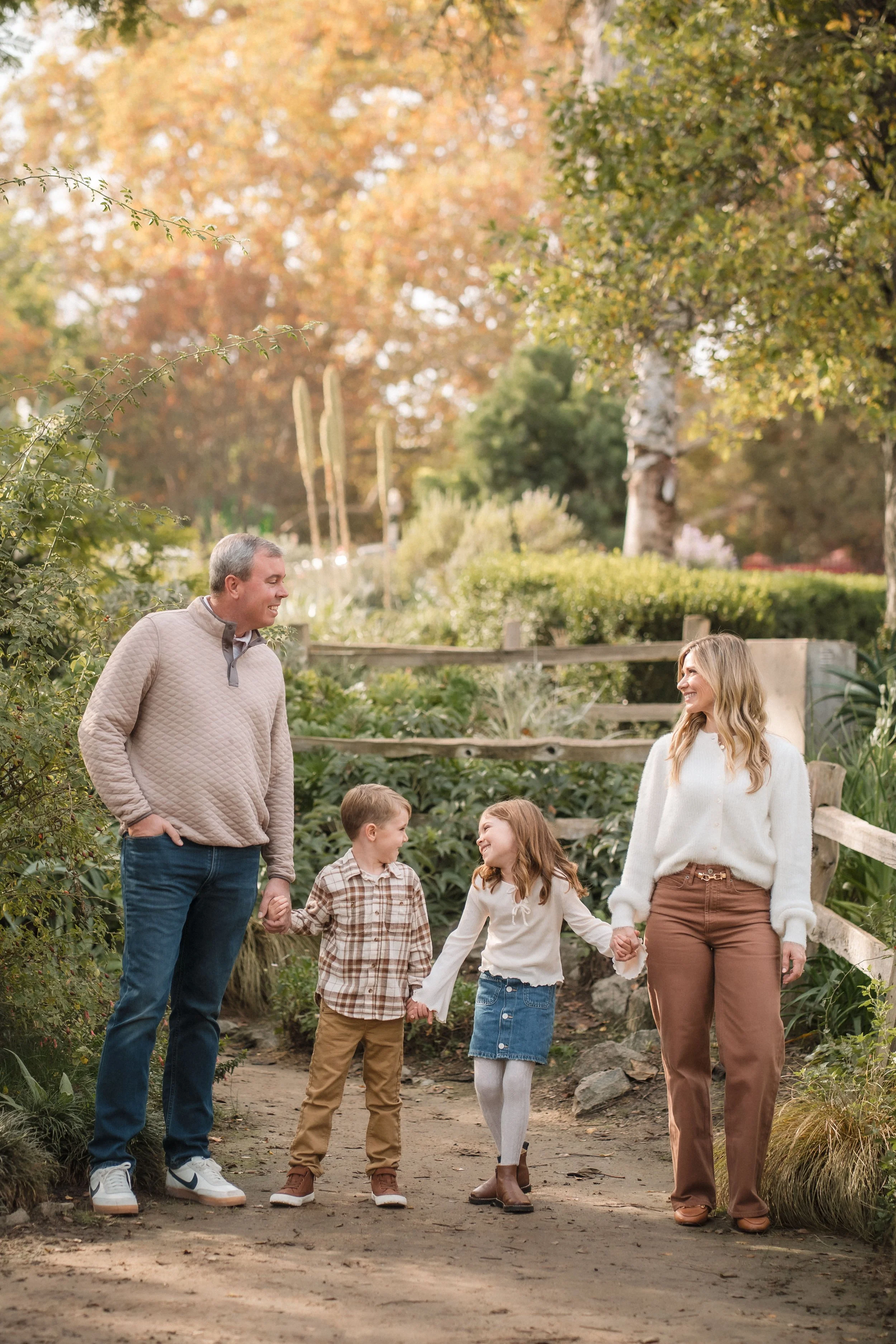 Family holds hands and smiles at each other during their family photo session with Sacramento Family Photographer, Katherine Nicole Photography