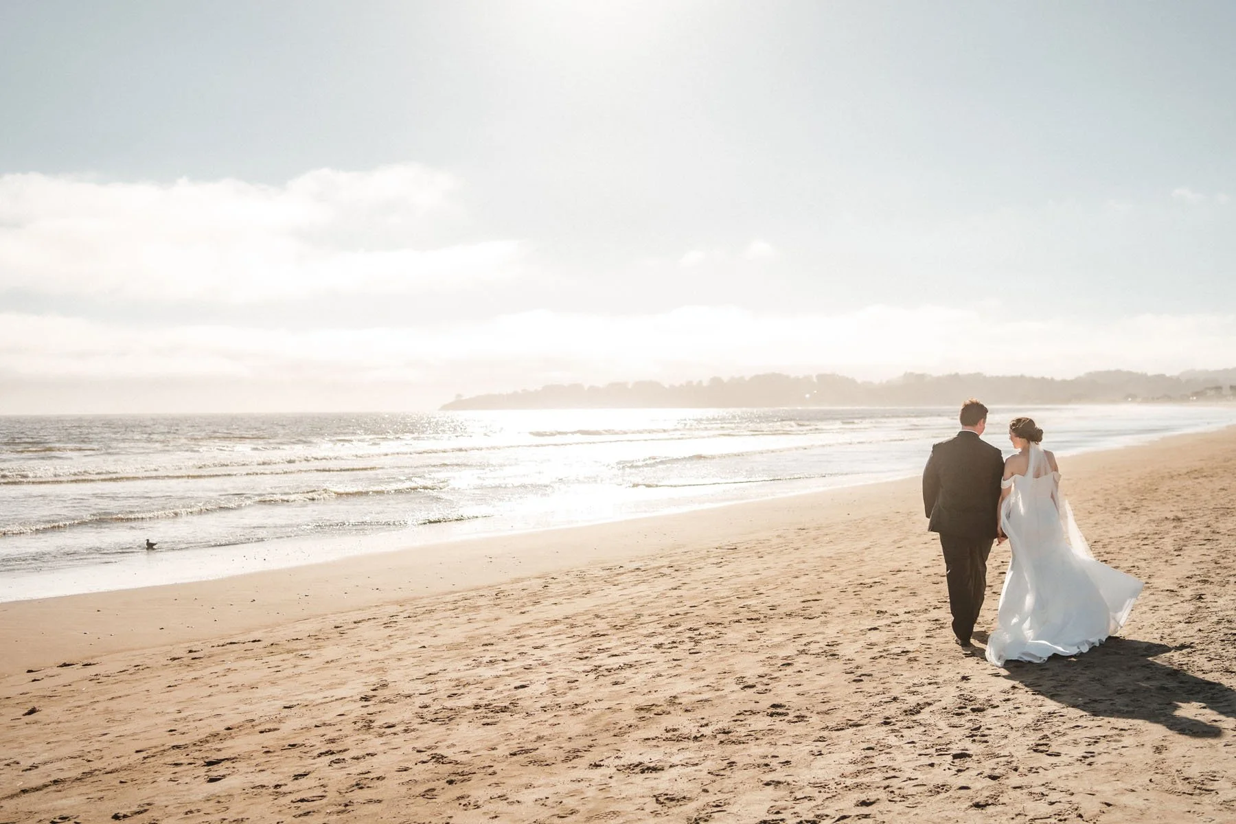 Bride and groom walk on the beach at their Stinson Beach wedding