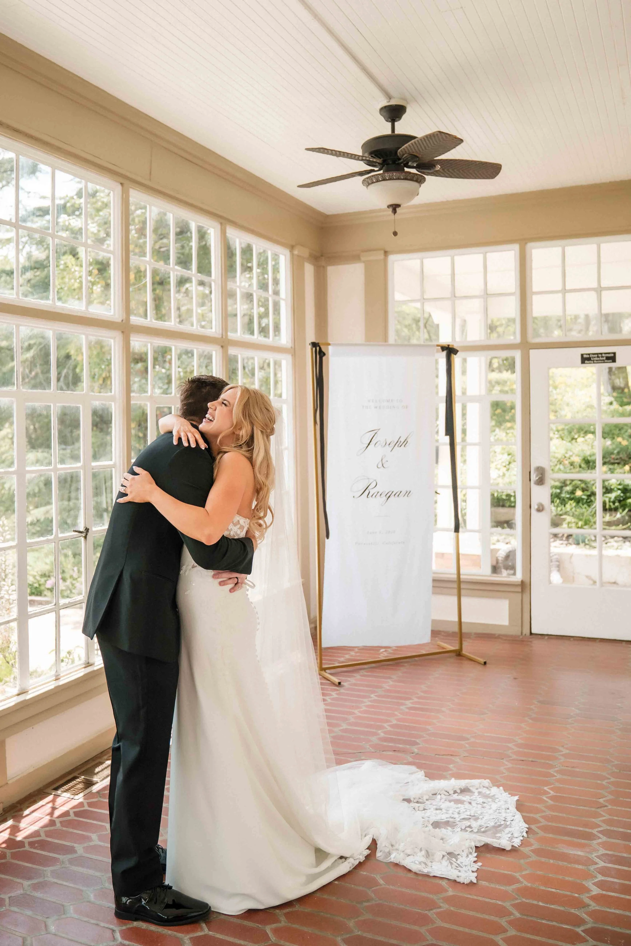 bride and groom embrace in sunroom of Monte Verde Inn