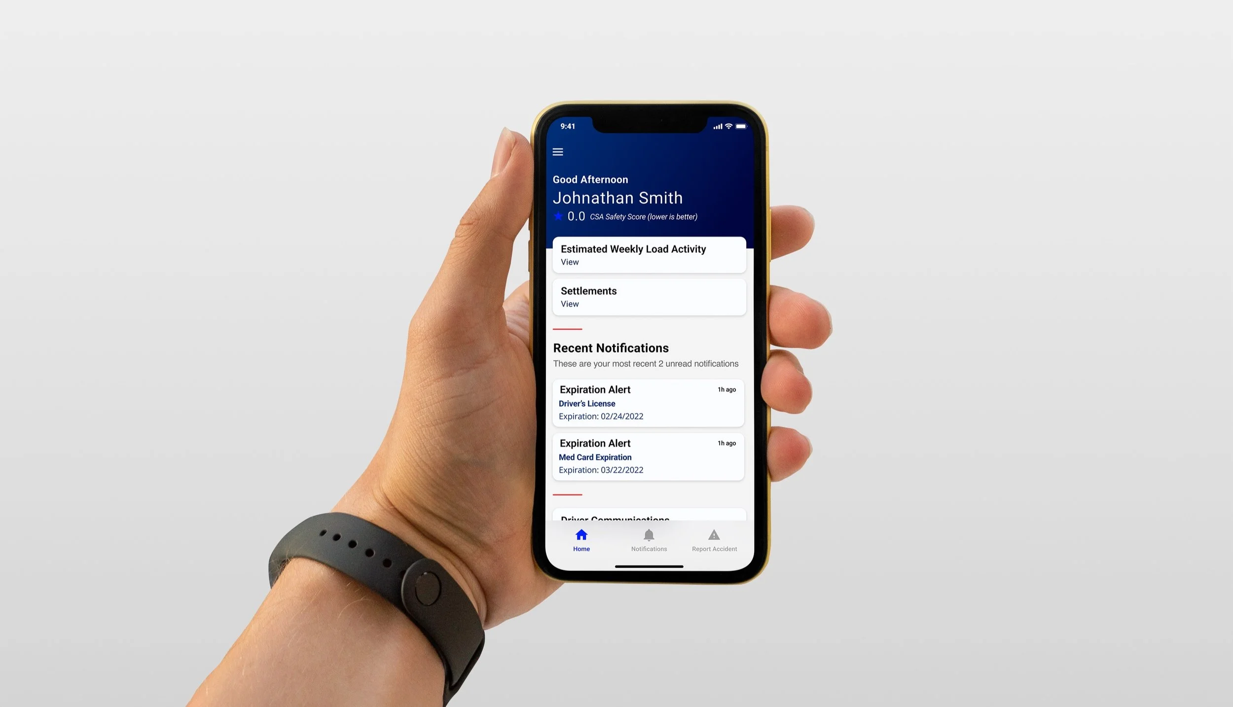 Person holding a smartphone displaying a driver safety app with notifications and account details on a plain white background.