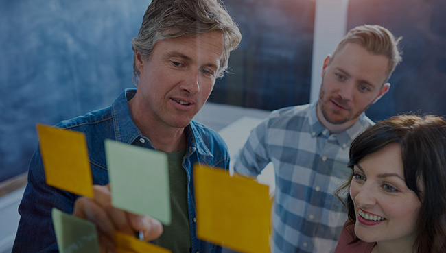Work colleagues brainstorming with sticky notes in a modern offi