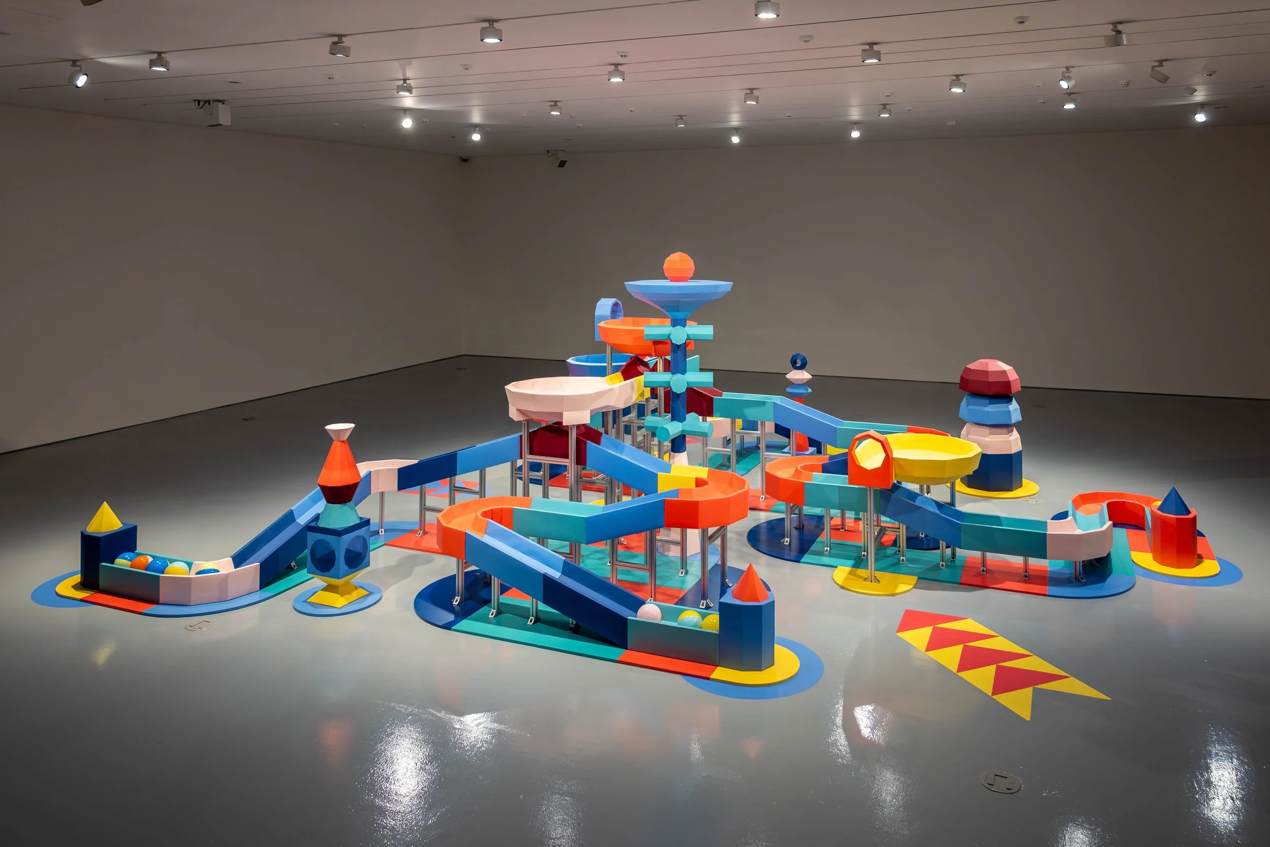 Cynthia Mak and STICKYLINE, Marble Run, 2026. This monumental, three-meter-tall polyhedral installation scales a classic childhood toy into a towering geometric metropolis of twisting roads, cascading structures, and labyrinthine pathways.
