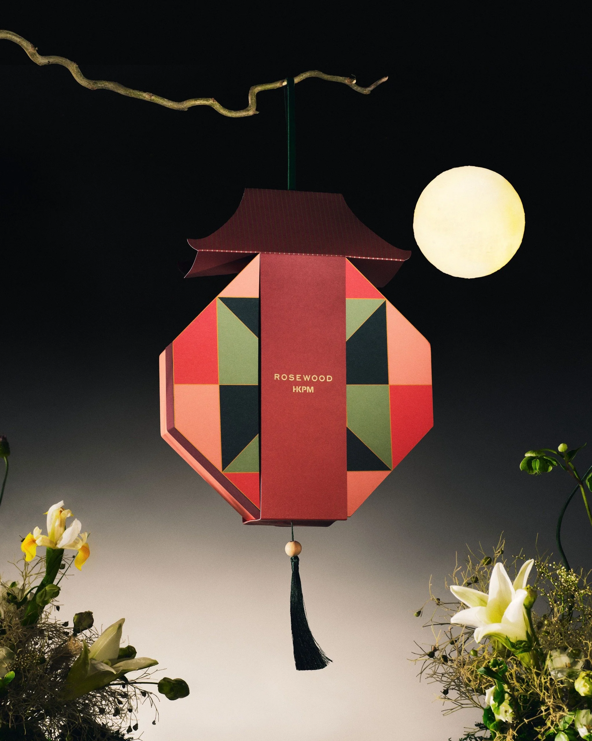 he Seric Lantern hanging mooncake packaging design by Cynthia Mak for Rosewood Hong Kong x Palace Museum collaboration, featuring a red Palace Museum-inspired roof, an octagonal geometric body, black tassel, and a full moon background with flowers