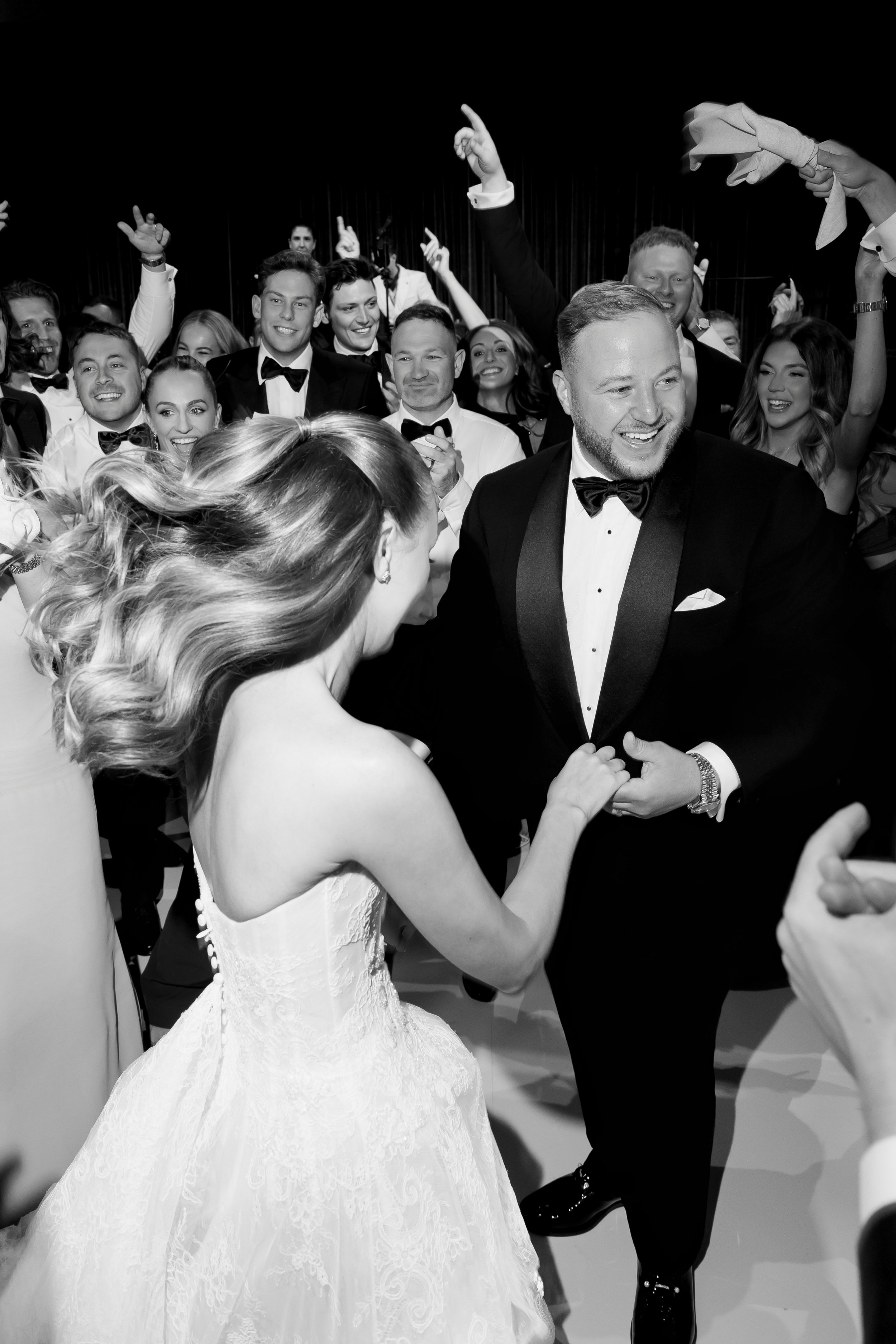 couple having fun on the dancefloor at their wedding reception with all of their guests