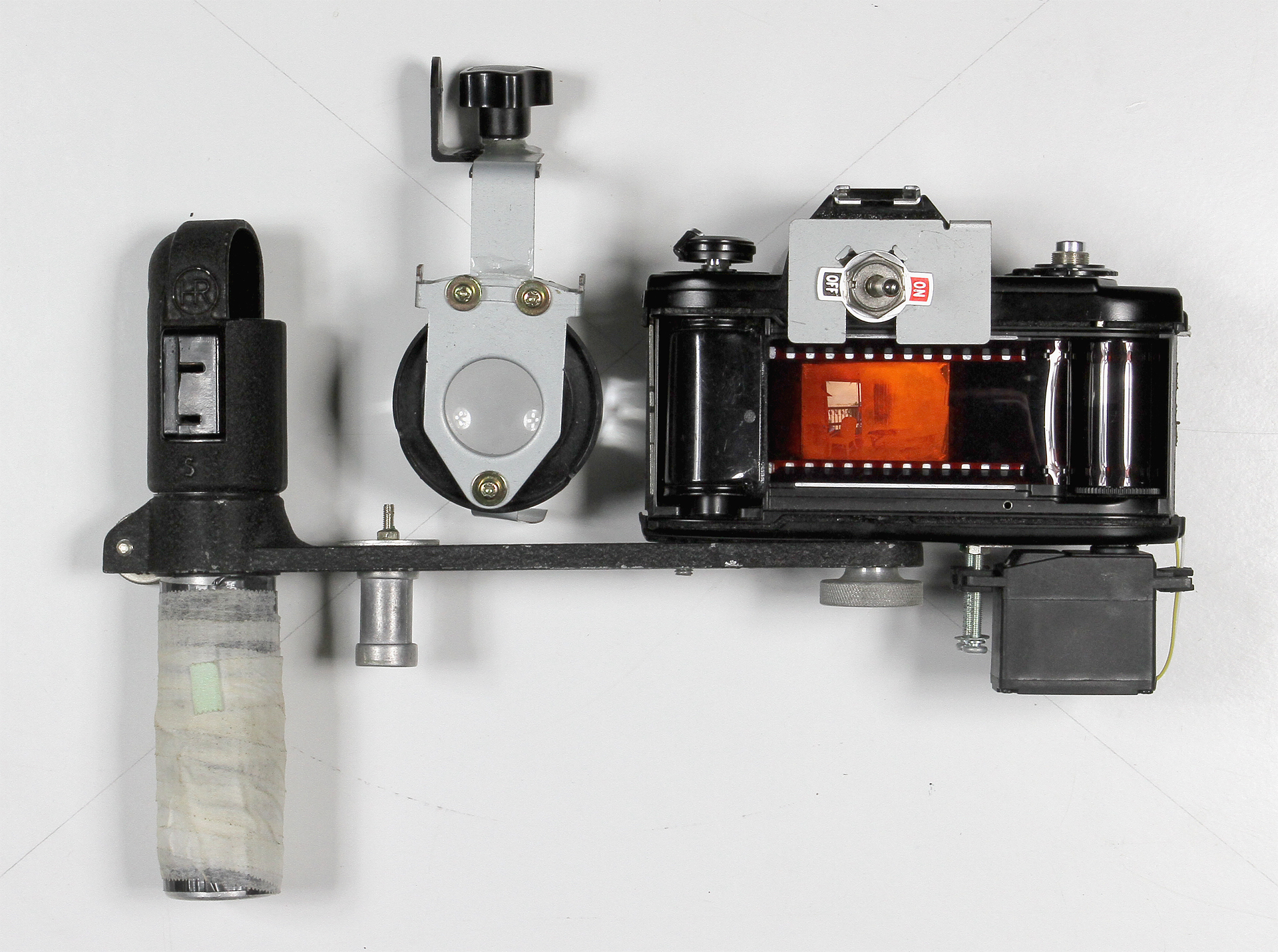   35mm Slide Film Viewer  2016.&nbsp; Nikon EM body, flash bracket, modified servo motor, SPST switch, 2xAA battery holder, white LEDs, Holga macro attachment, SLR ground glass, metal pieces from a broken printer, nuts, screws, super glue. 