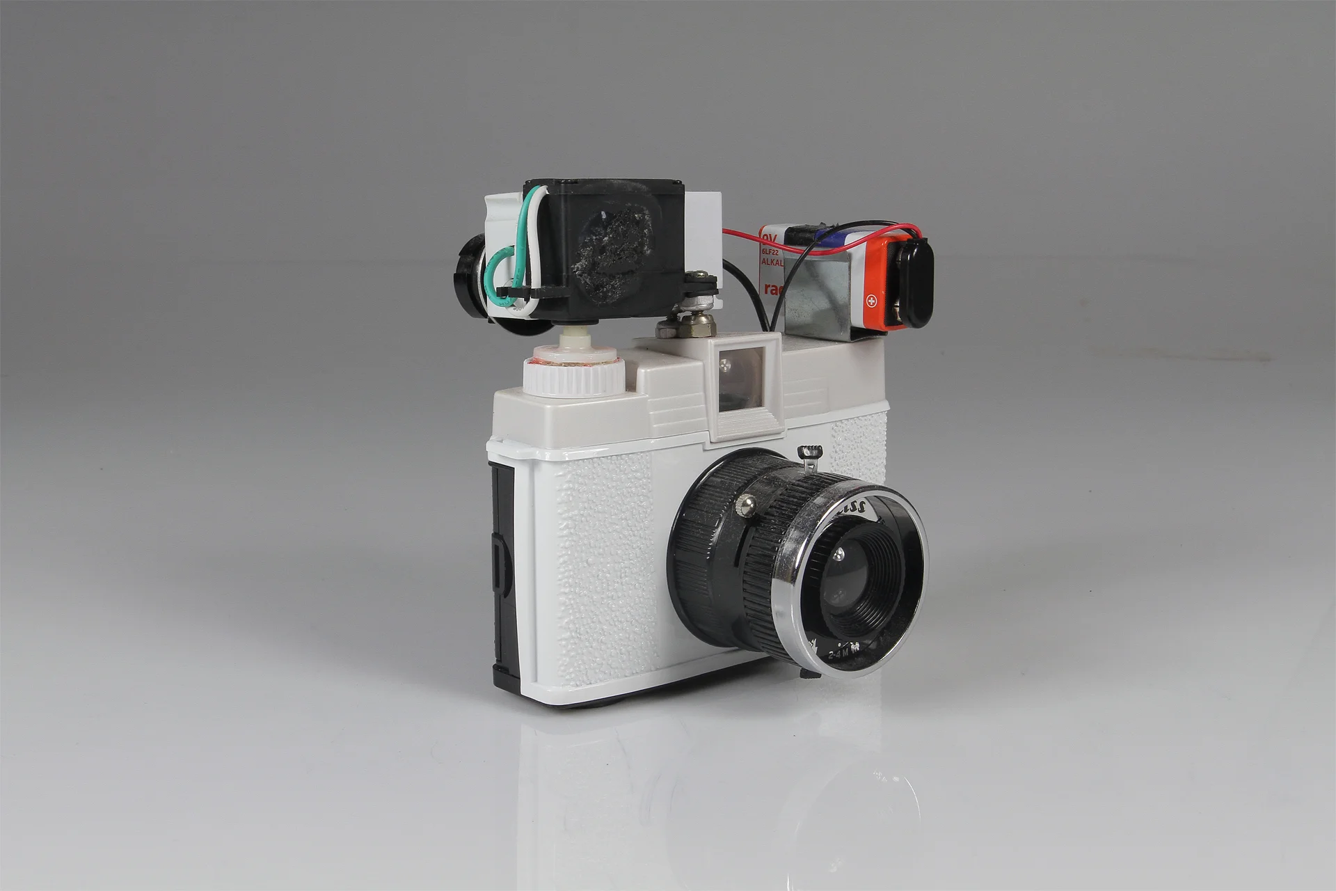 Diana Slitscan Camera 2016. Modified Diana+ with 35mm film back for Strip Photography. Diana+ camera, modified servo motor, pulse-width modulation circuit (for motor speed control), 9v battery, battery clip, electrical wire, salvaged nuts and bolts.