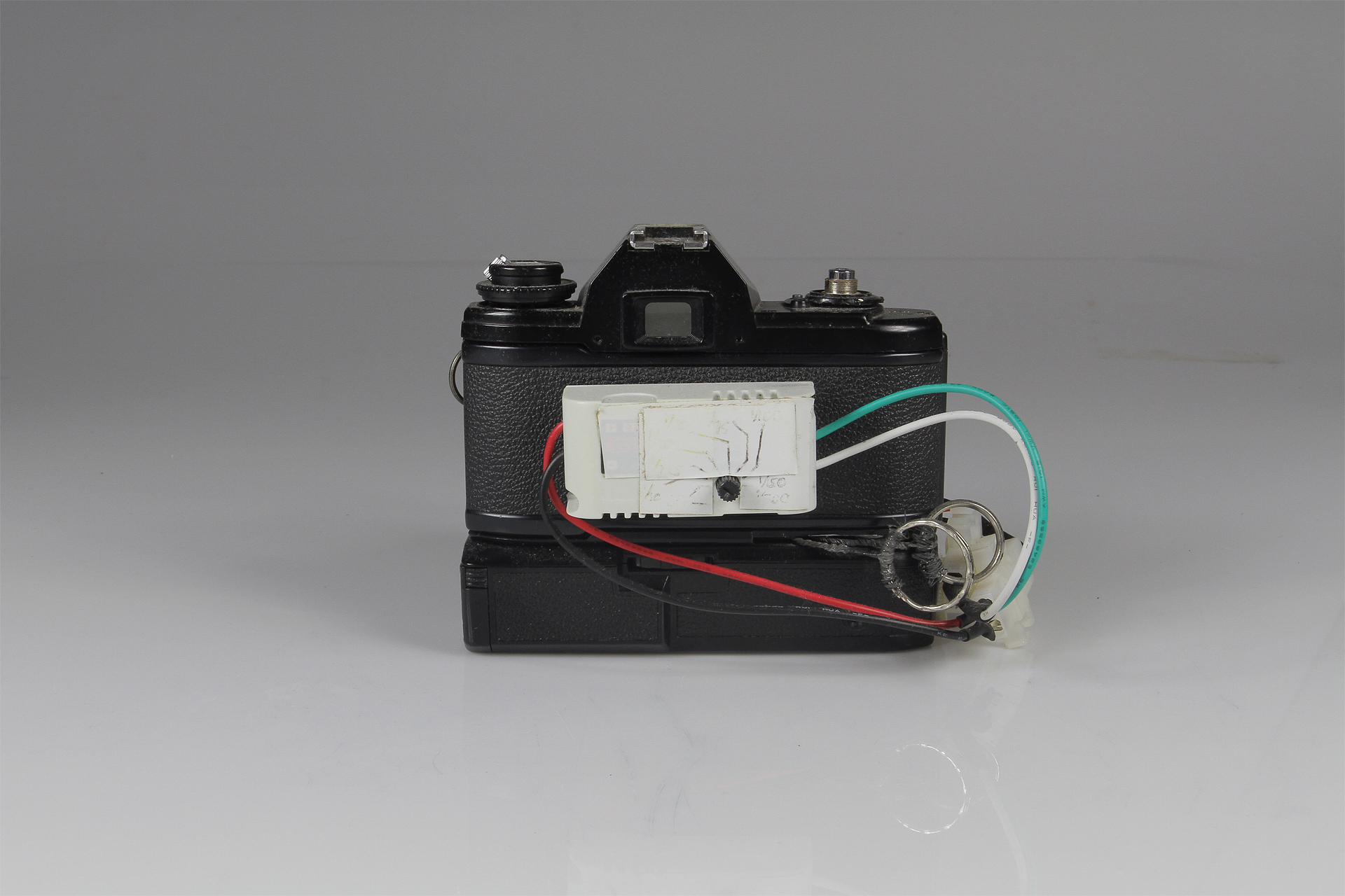   Nikon Slitscan Camera  2014.&nbsp; Modified Nikon EM SLR and Motor Drive for Strip Photography.&nbsp; Nikon EM SLR w/ motor drive, pulse-width modulation circuit (motor speed control), black-rubberized 4x5" film (to form the slit), electrical wire,