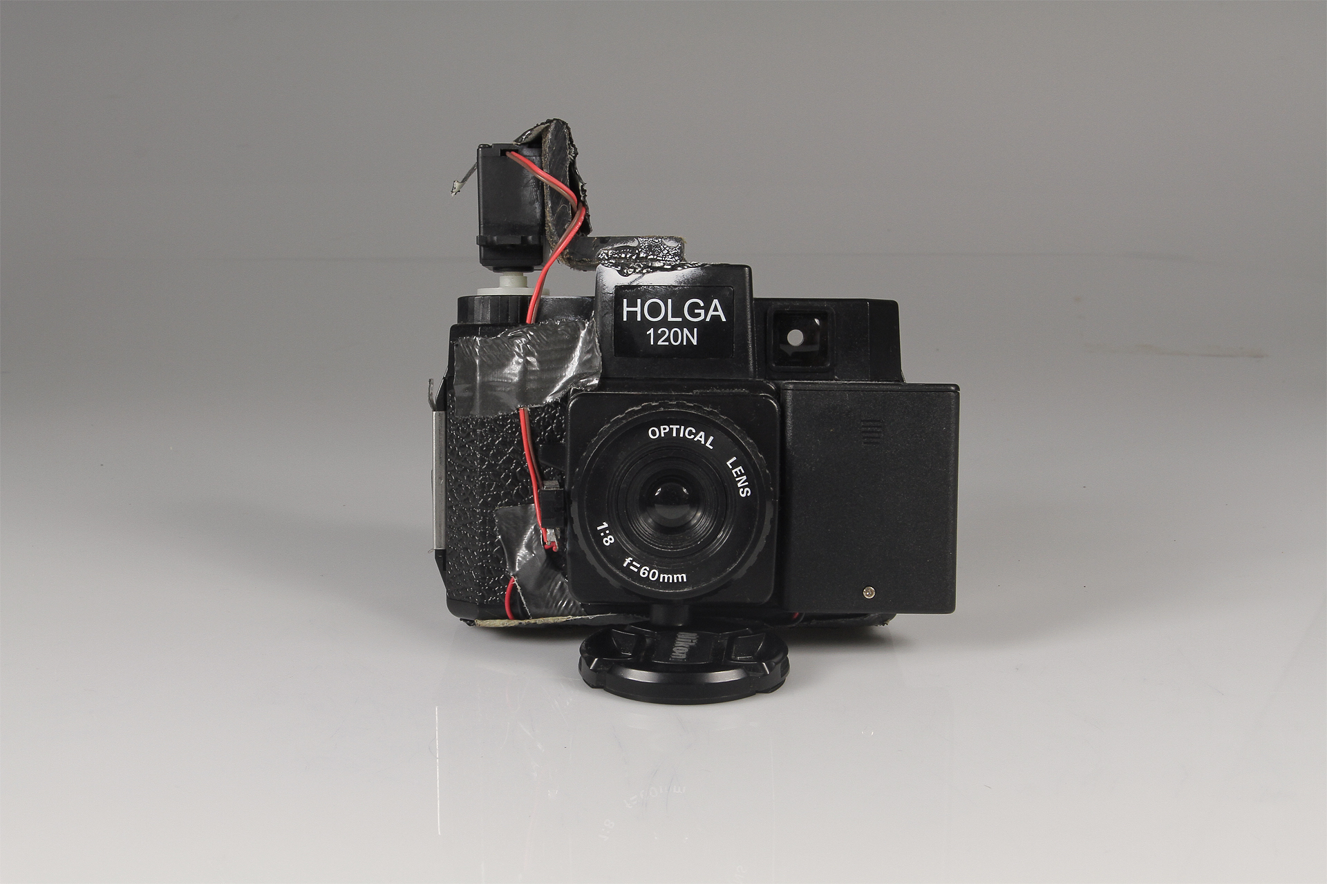   Holga Slitscan Camera  2013.&nbsp; Modified Holga for Strip Photography.&nbsp; Holga camera, modified servo motor, 3xAAA battery pack, SPST switch, plastic L bracket, black-rubberized 4x5 film (to make the slit in the camera), electrical wire, duct
