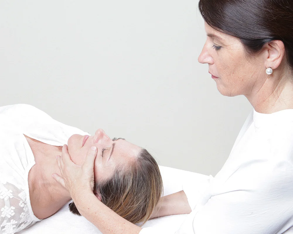 Der bekleidete Patient schließt die Augen. Die Behandlung verläuft ohne Druck.