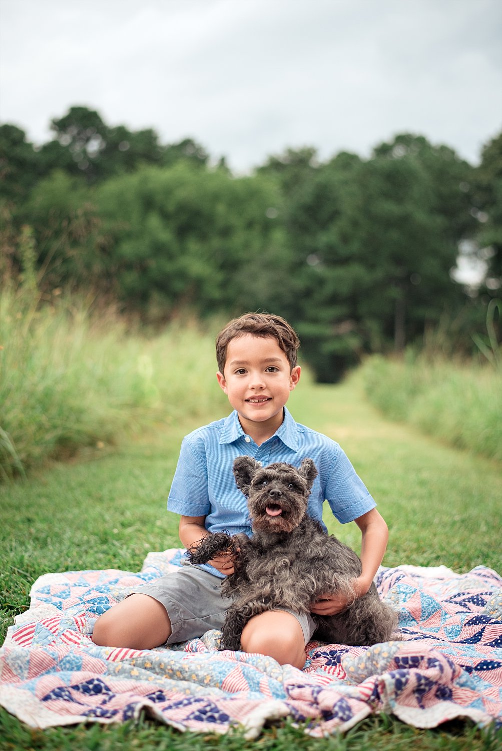 boy and schnauzer sitting on blanket