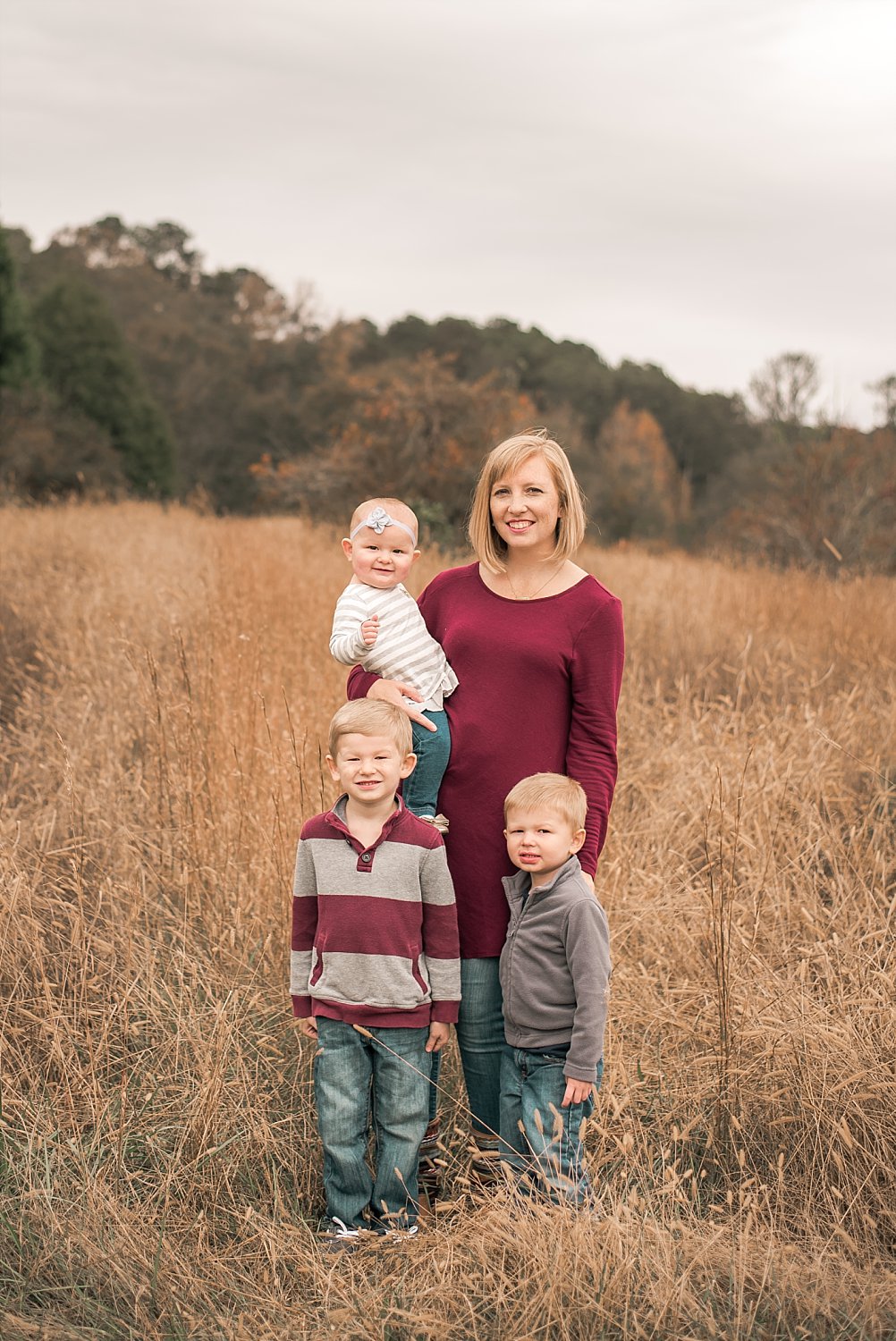mother and 3 kids standing in tall grass field at Berry Patch Farms Woodstock, GA