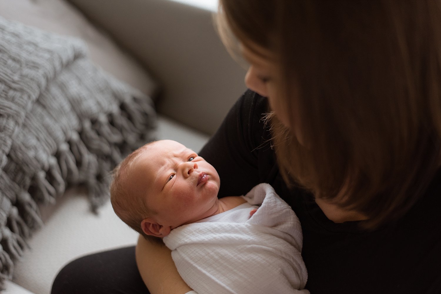 newborn baby looking up at mom