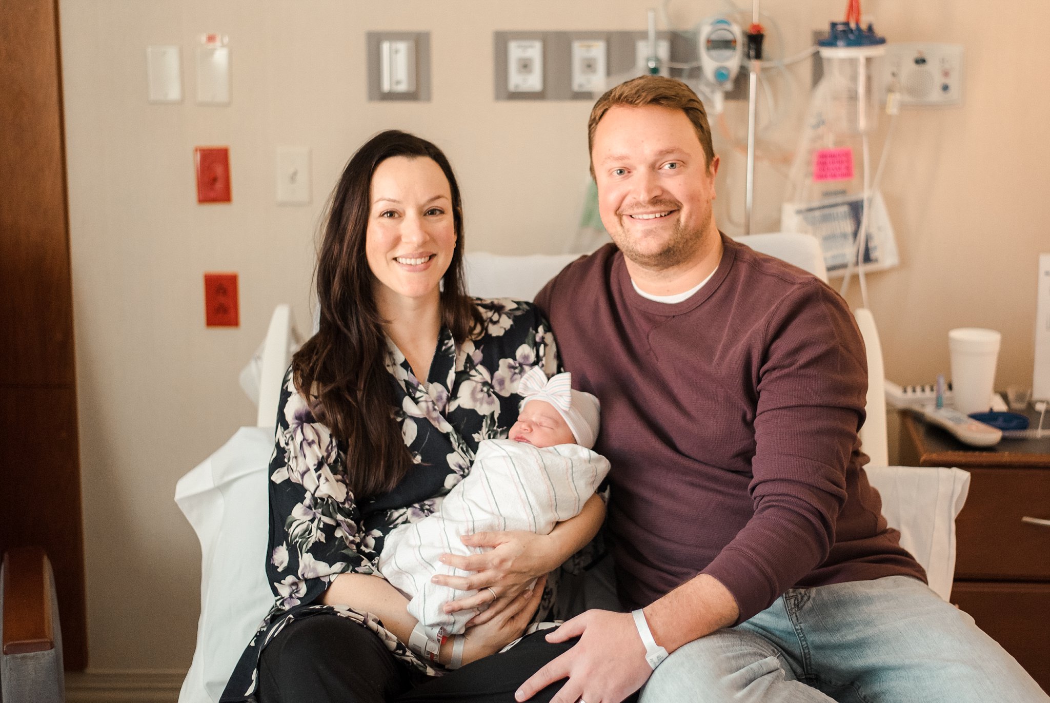 Parents sitting on hospital bed with newborn baby | Emory Johns Creek Hospital