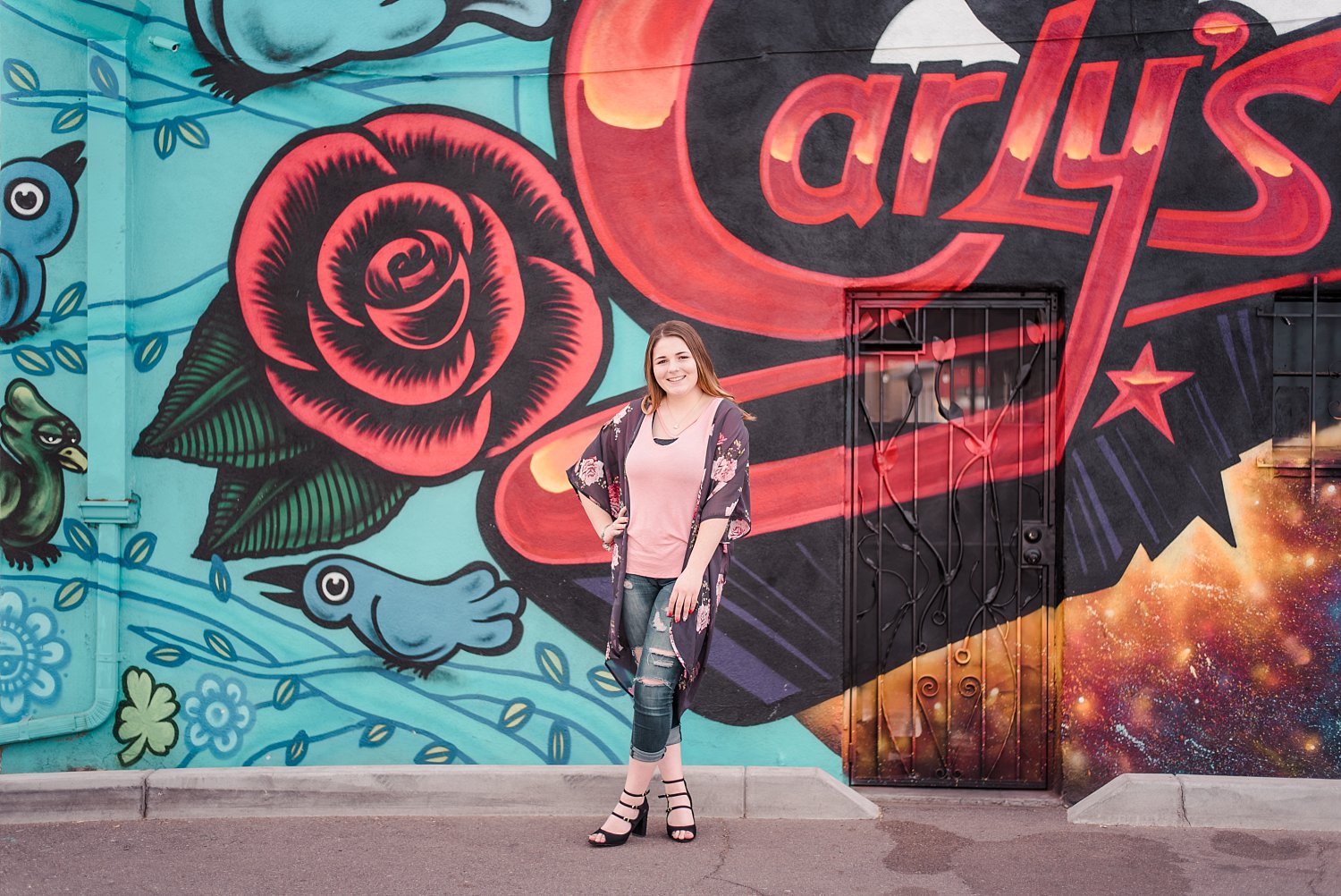 Senior girl in front of painted mural in city