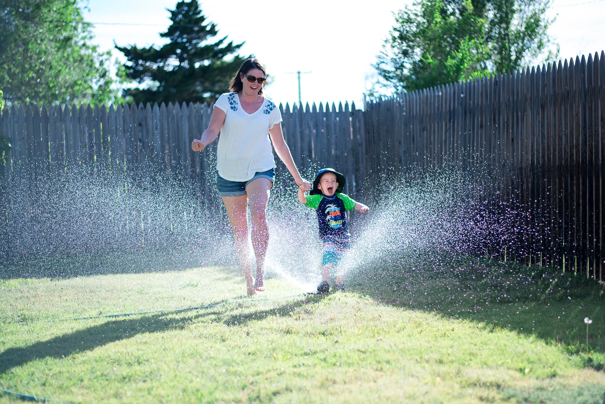 mother and son running through sprinkler | Summer Bucket List | adriennelouisephotography.com