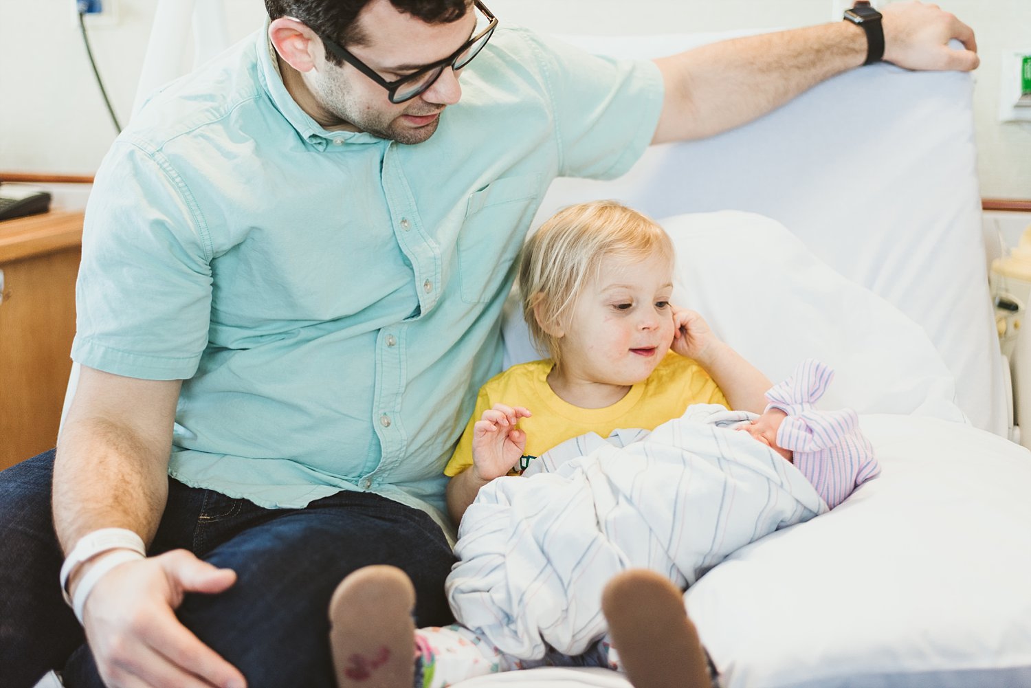 Dad and toddler holding baby