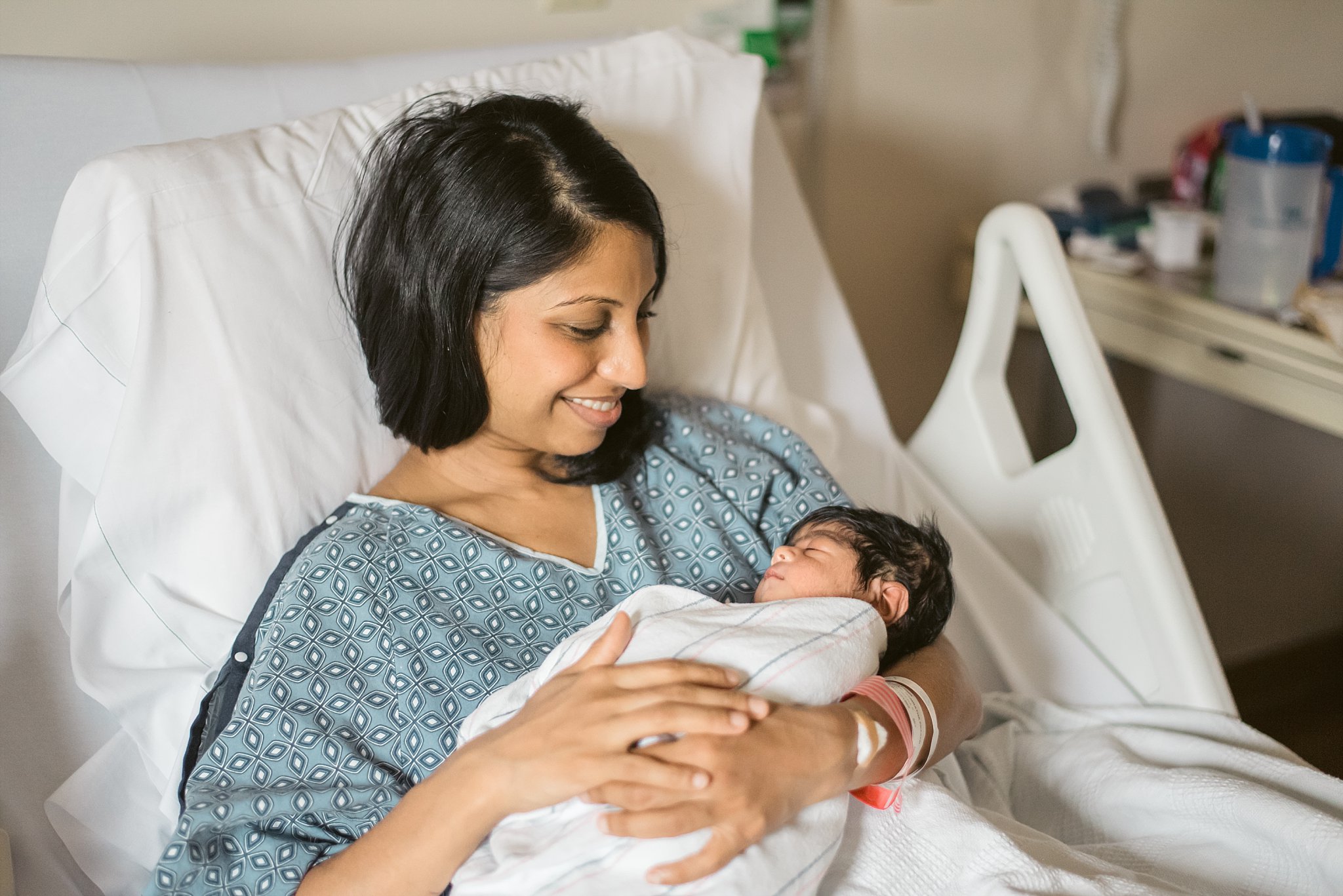 Mom looking at newborn baby boy in hospital bed