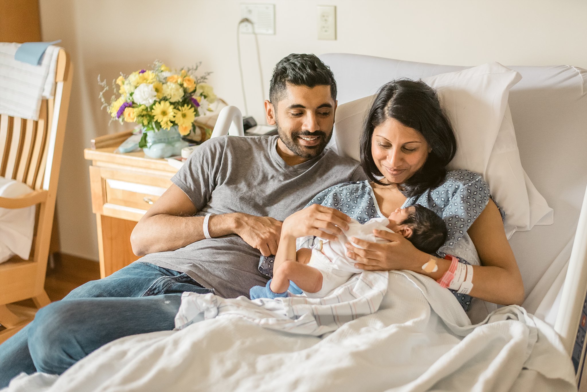 Mom and Dad sitting in hospital bed looking at newborn baby boy at Northside Atlanta Hospital