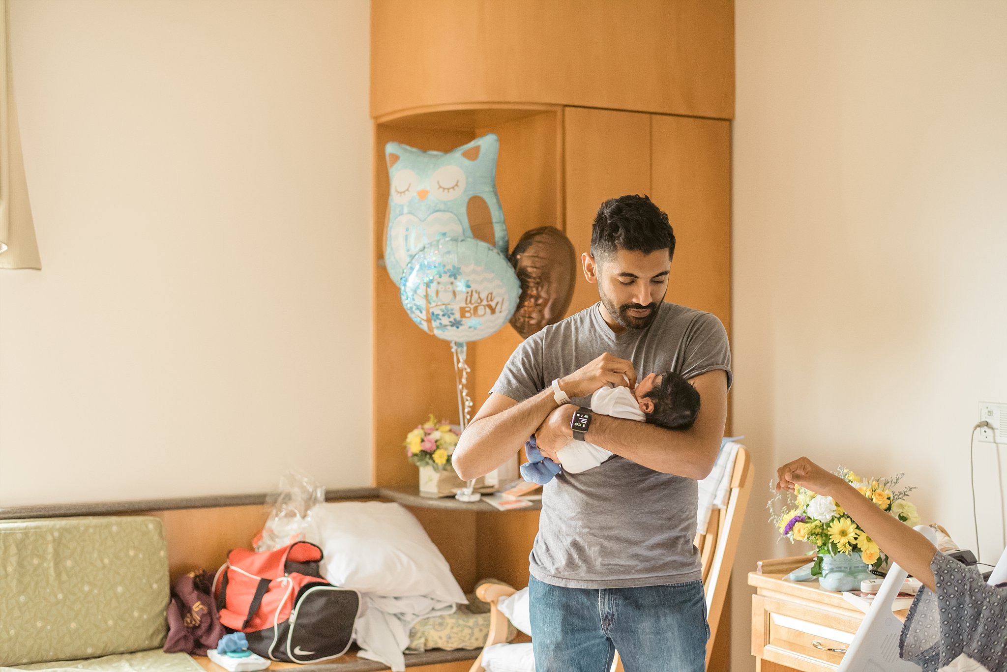 Dad holding baby in hospital room