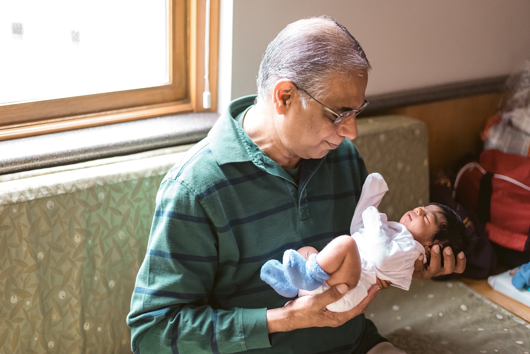 grandfather holding newborn baby