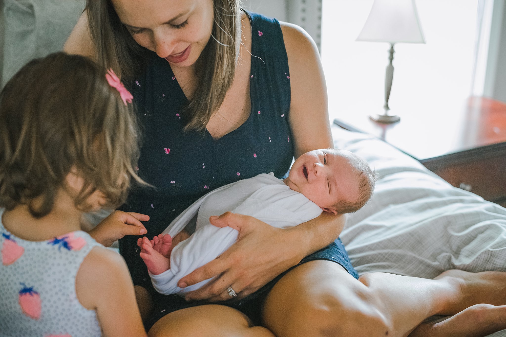 mom holding smiling newborn