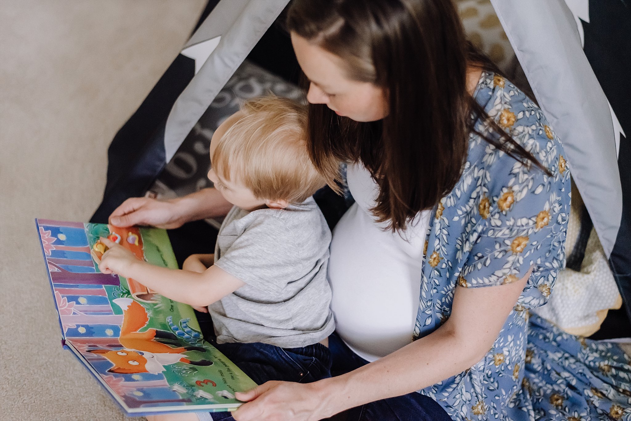 pregnant mother reading to toddler boy