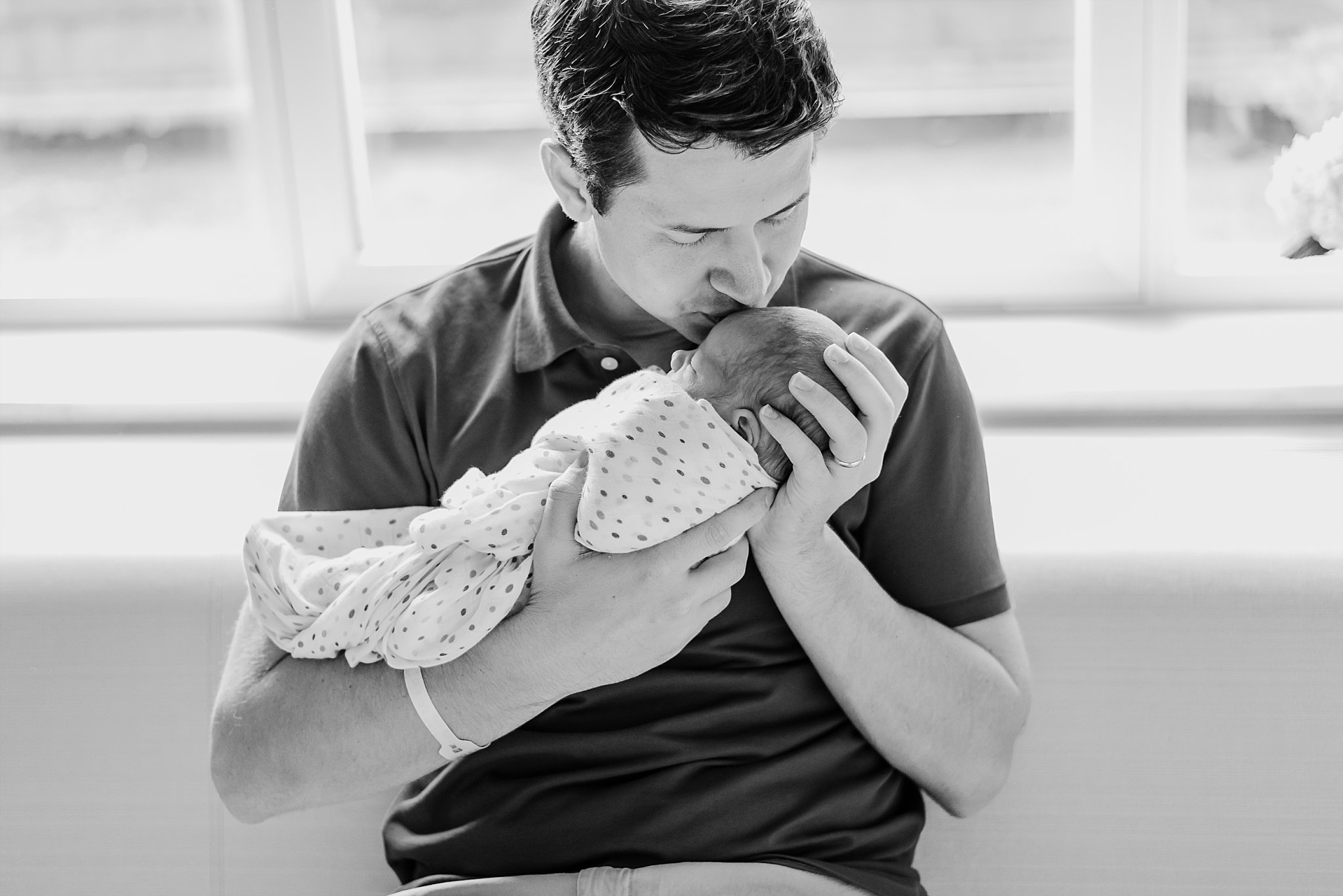 father kissing newborn baby boy