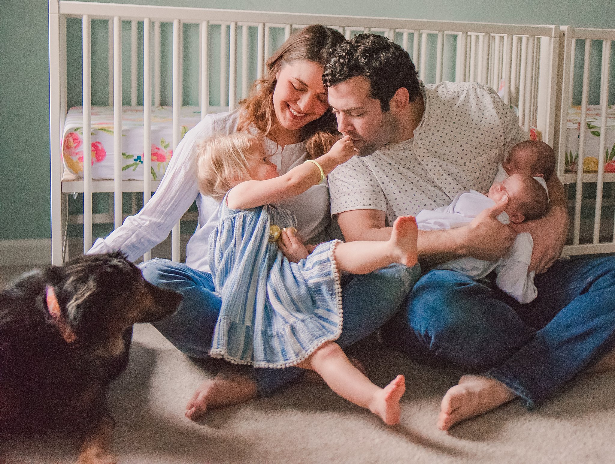 parents, toddler, newborn twins, dog in front of crib