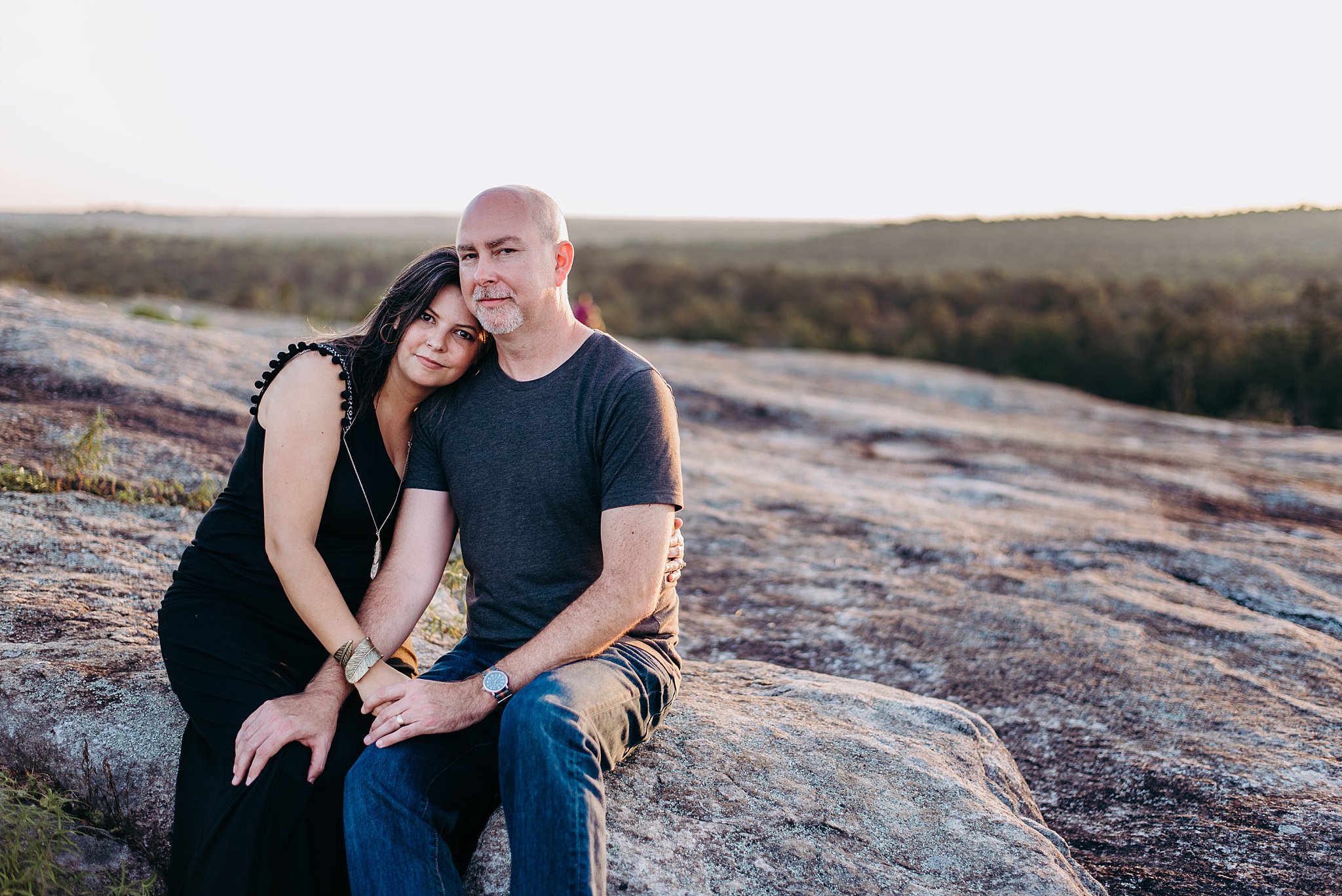 Couple sitting on rock at sunset at Arabia Mountain Atlanta