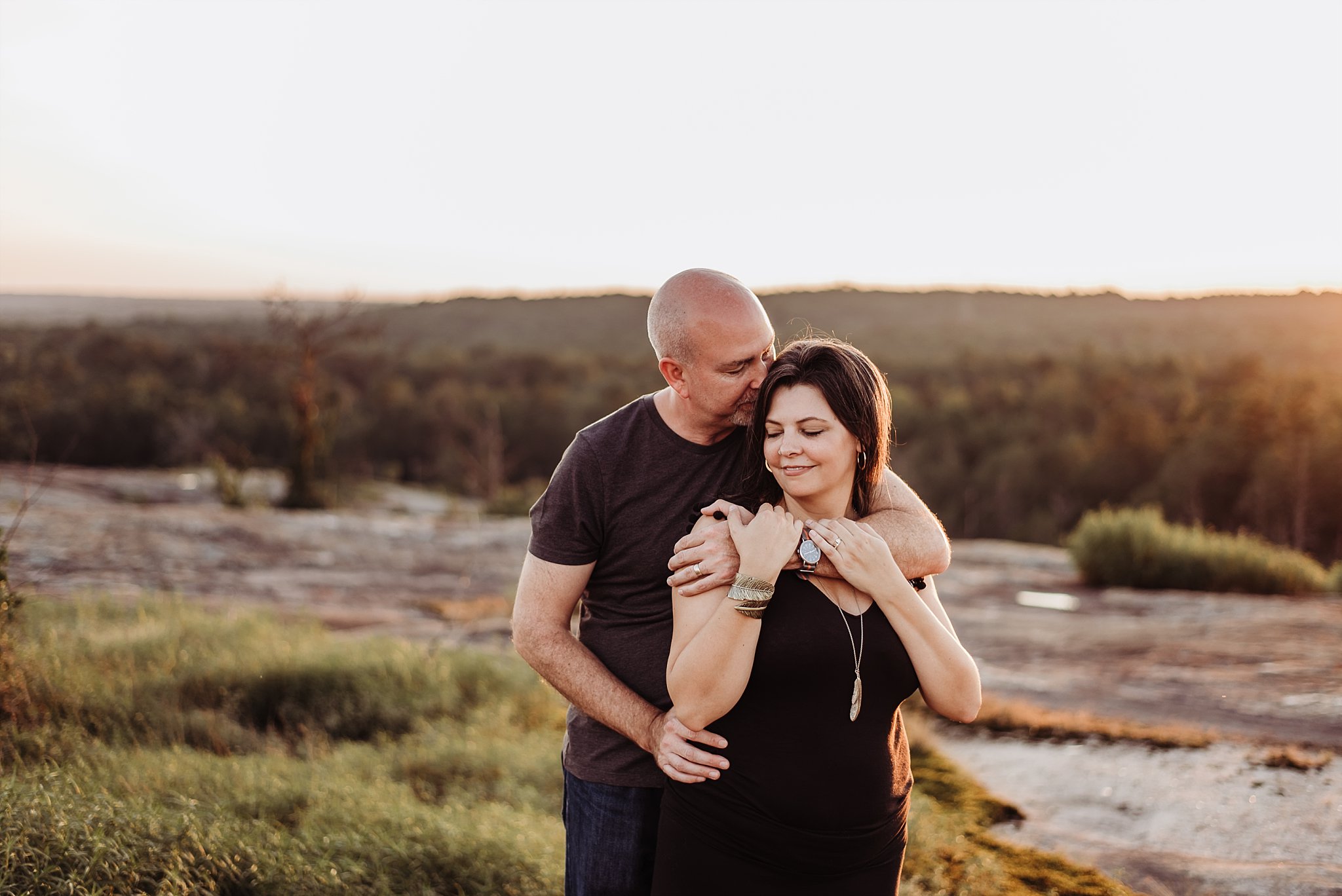 Couple embracing on Arabia Mountain at sunset