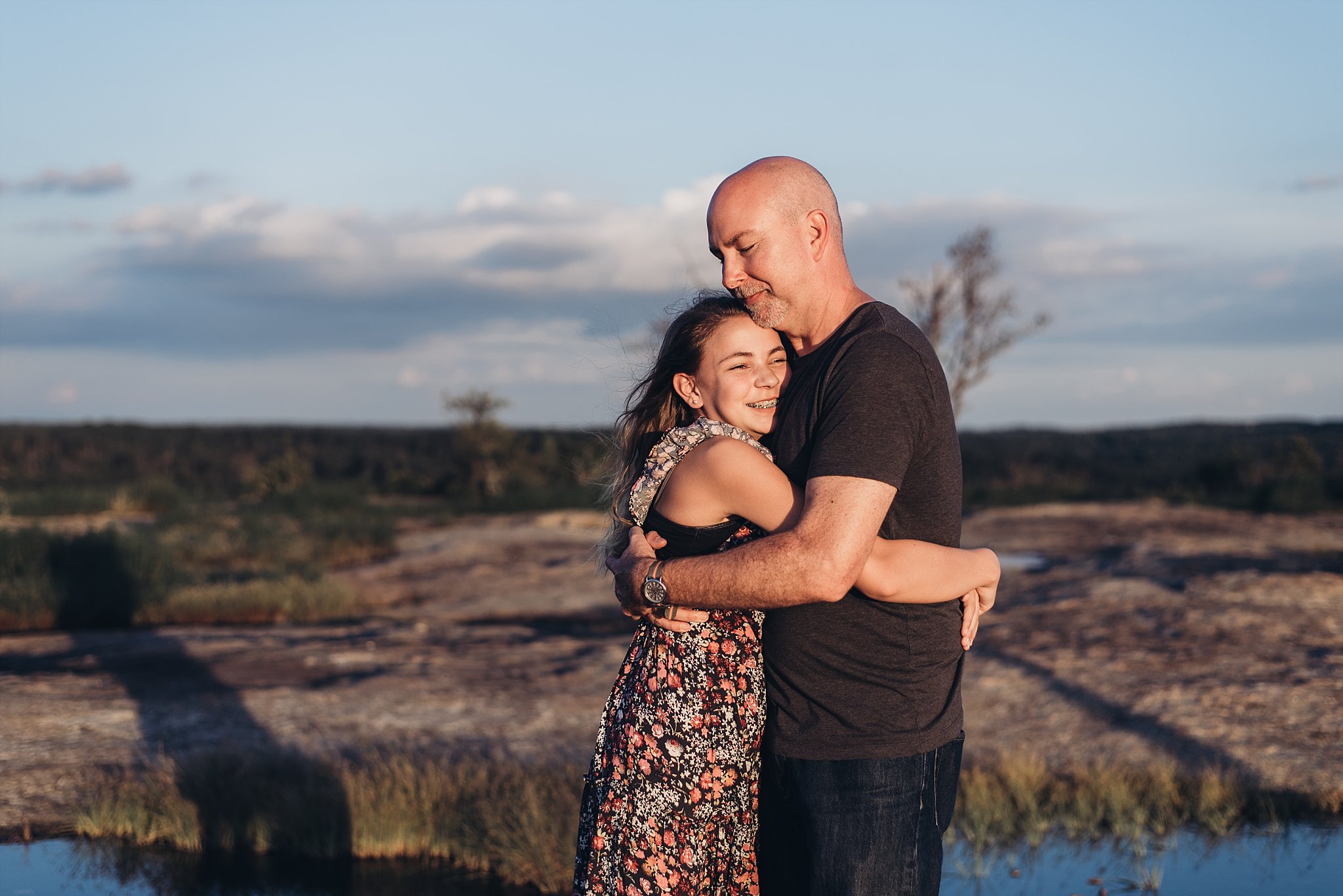 daughter hugging dad at Arabia Mountain top