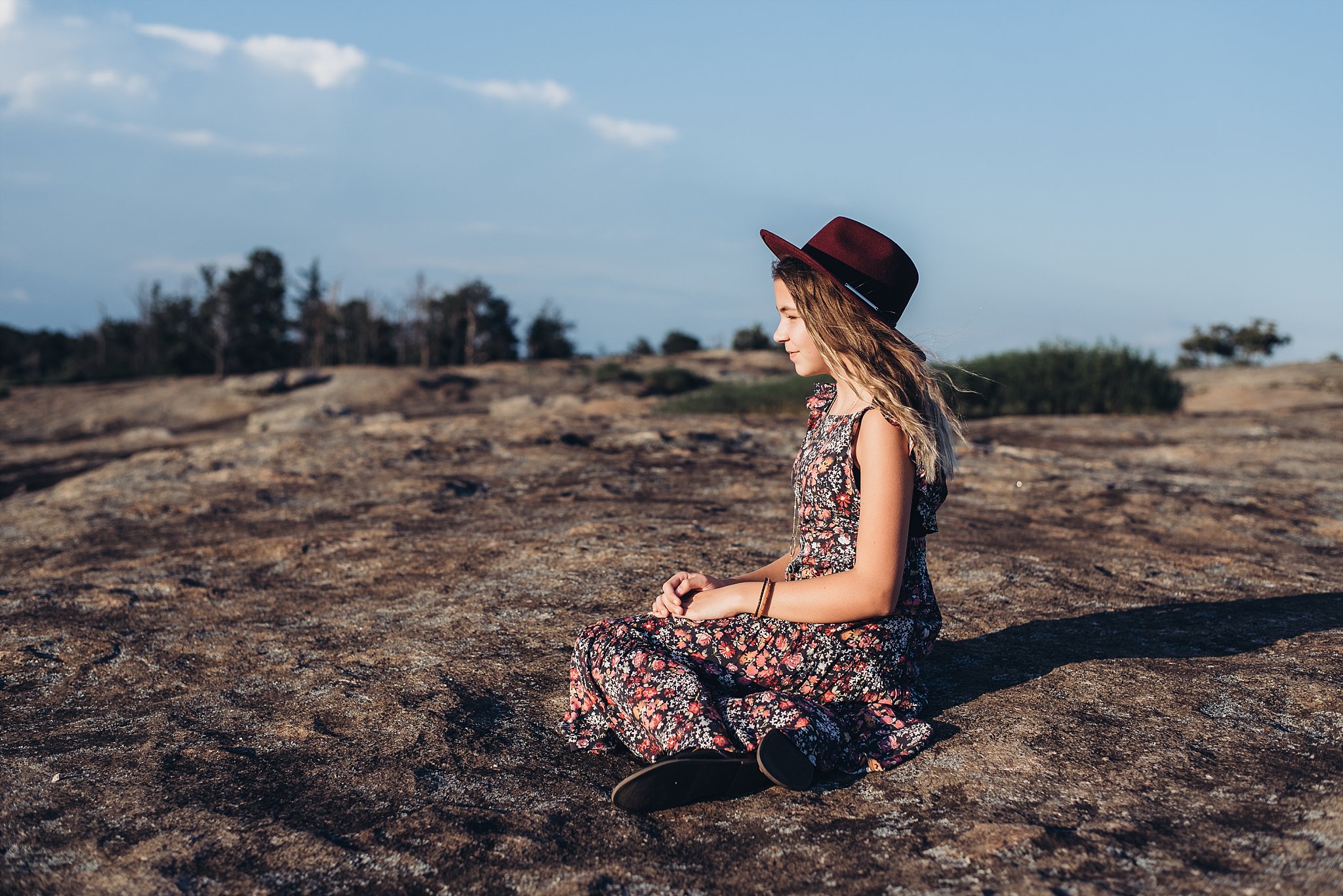 girl sitting wearing red hat looking out at Arabia Mountain Atlanta