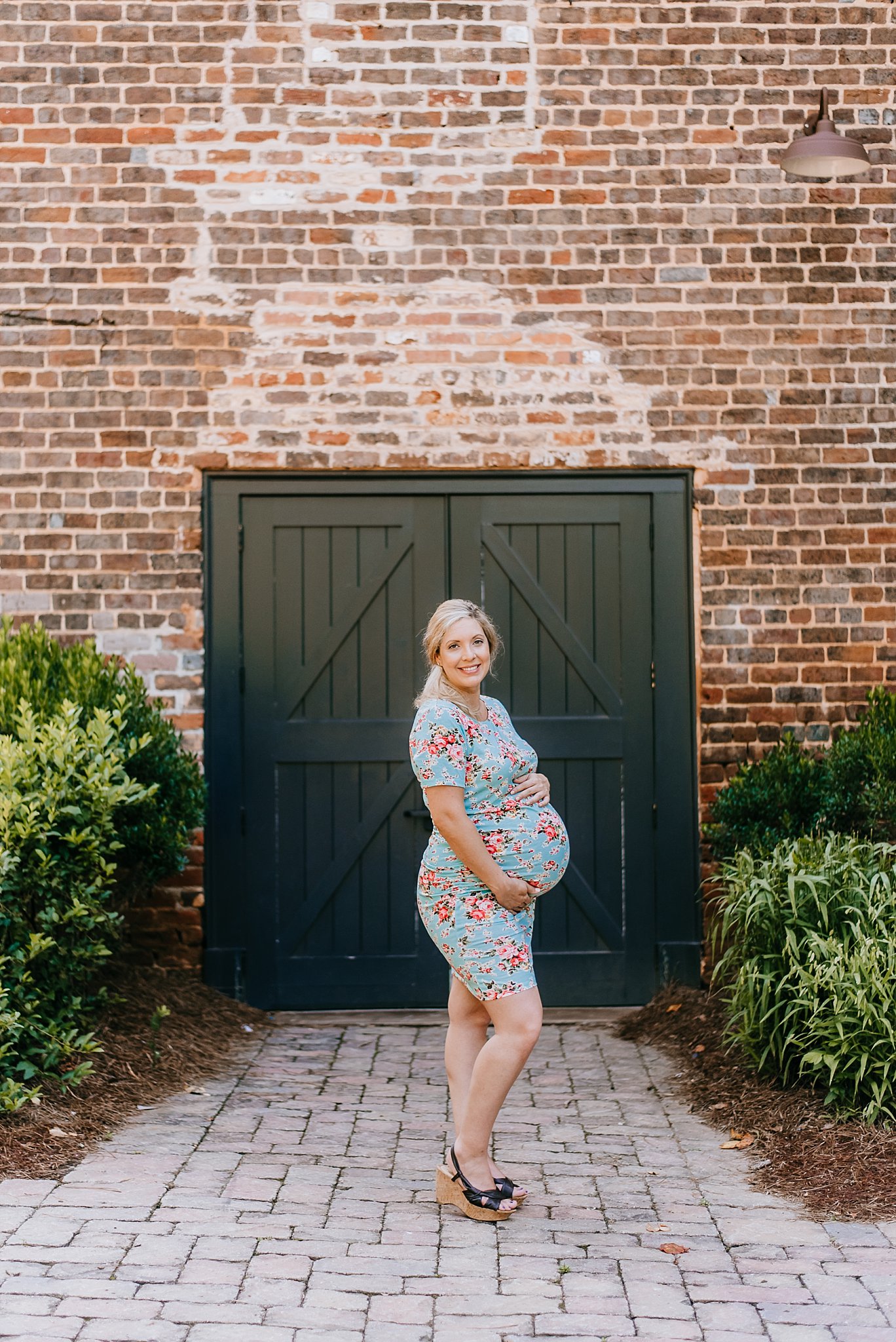 pregnant mom in floral dress at Roswell Mill ruins