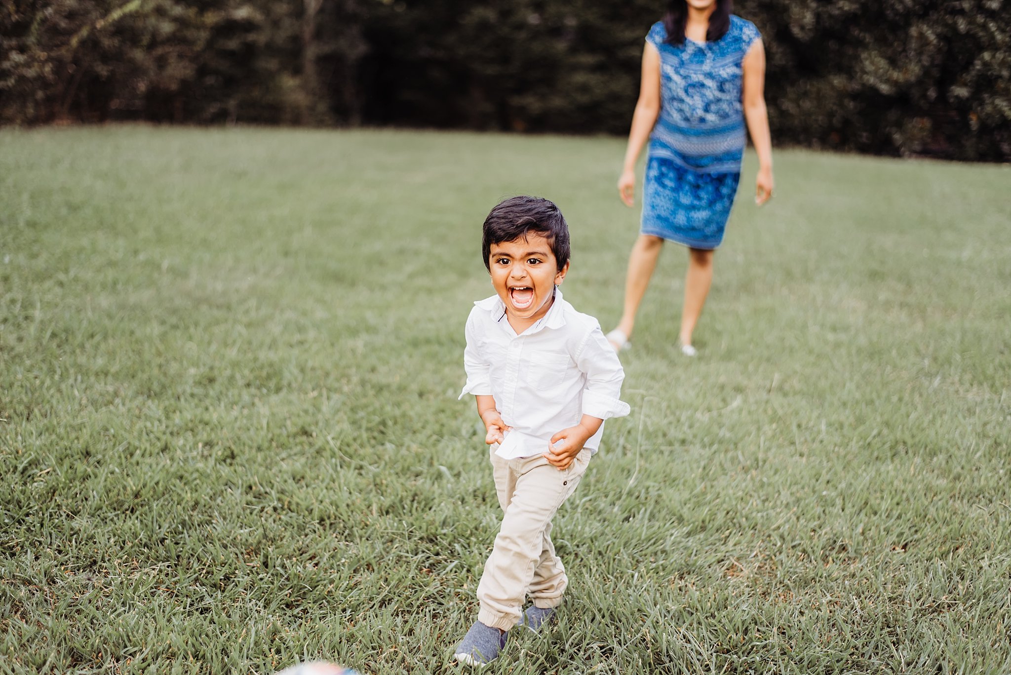 toddler boy laughing and kicking ball