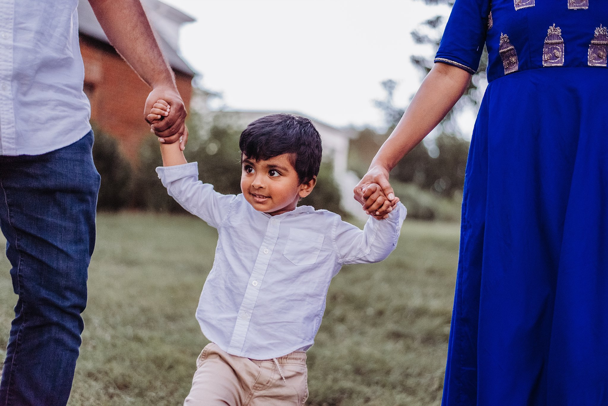 boy holding mom and dad's hands 