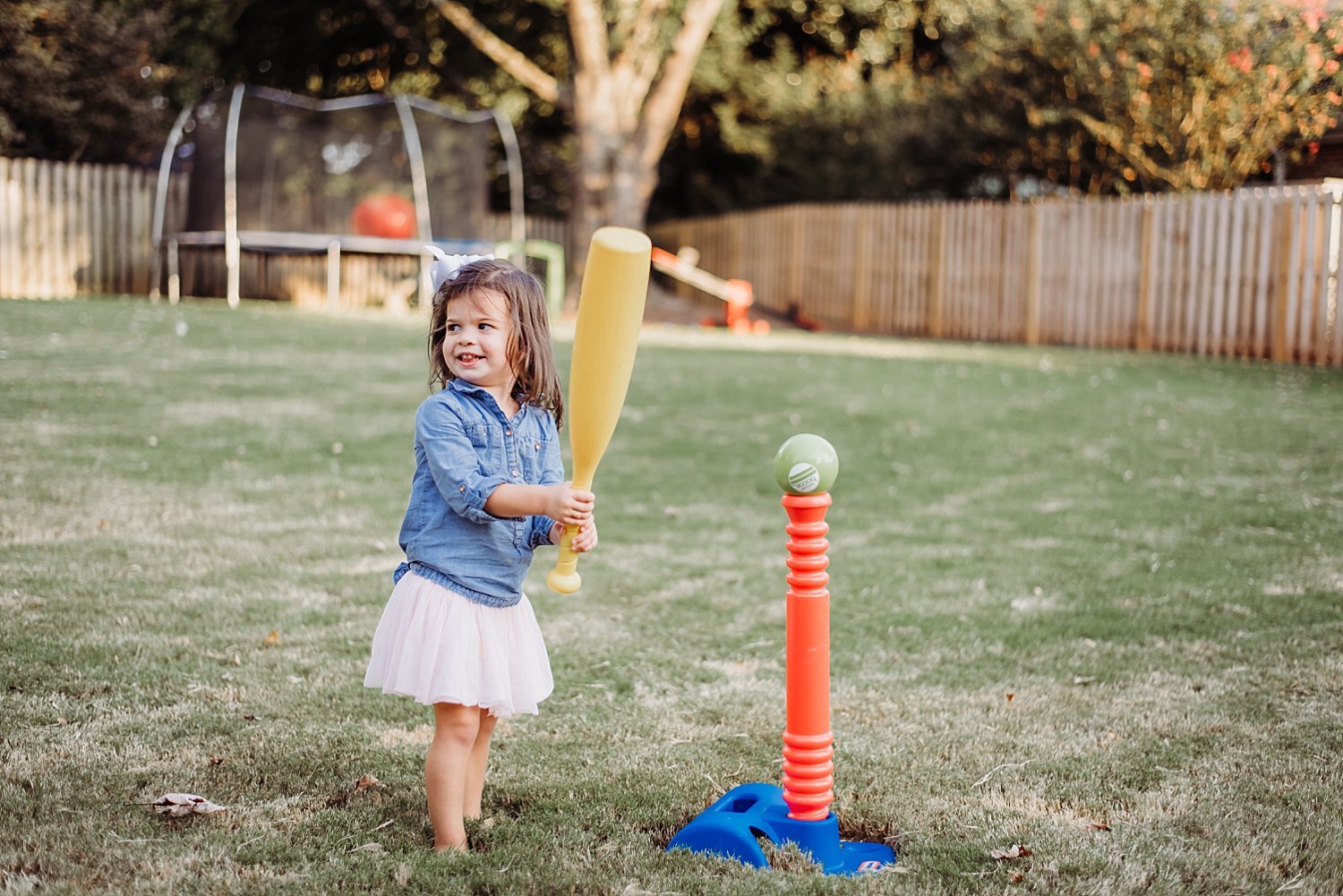 toddler girl playing t-ball in back yard