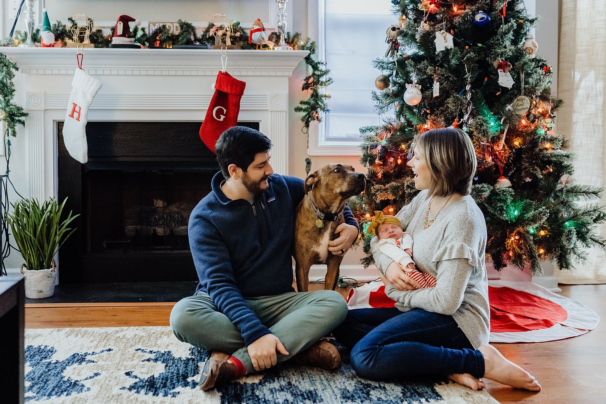 Family with dog in front of Christmas tree