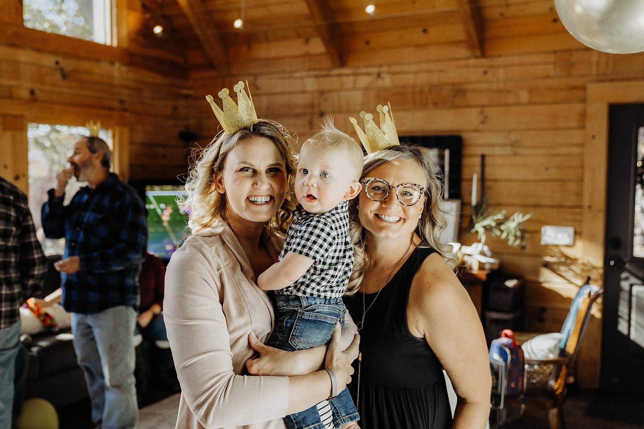 sisters with little boy at first birthday party