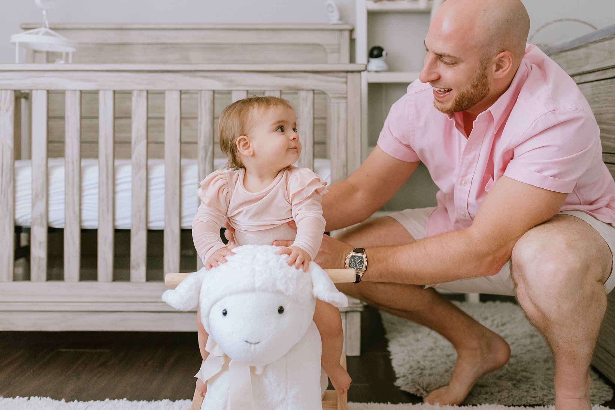 baby girl on stuffed lamb looking at dad | Atlanta Baby Photographer