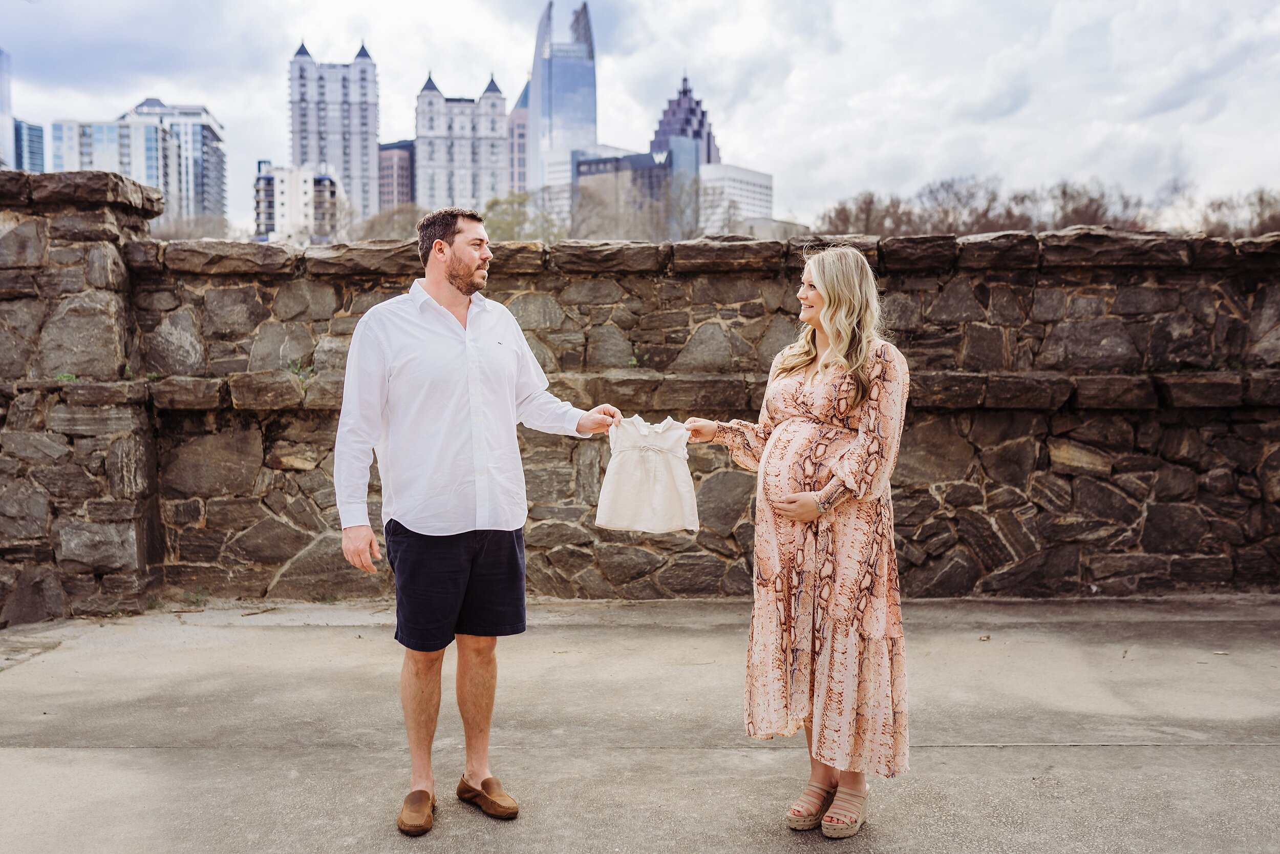 Couple holding baby girl dress between them