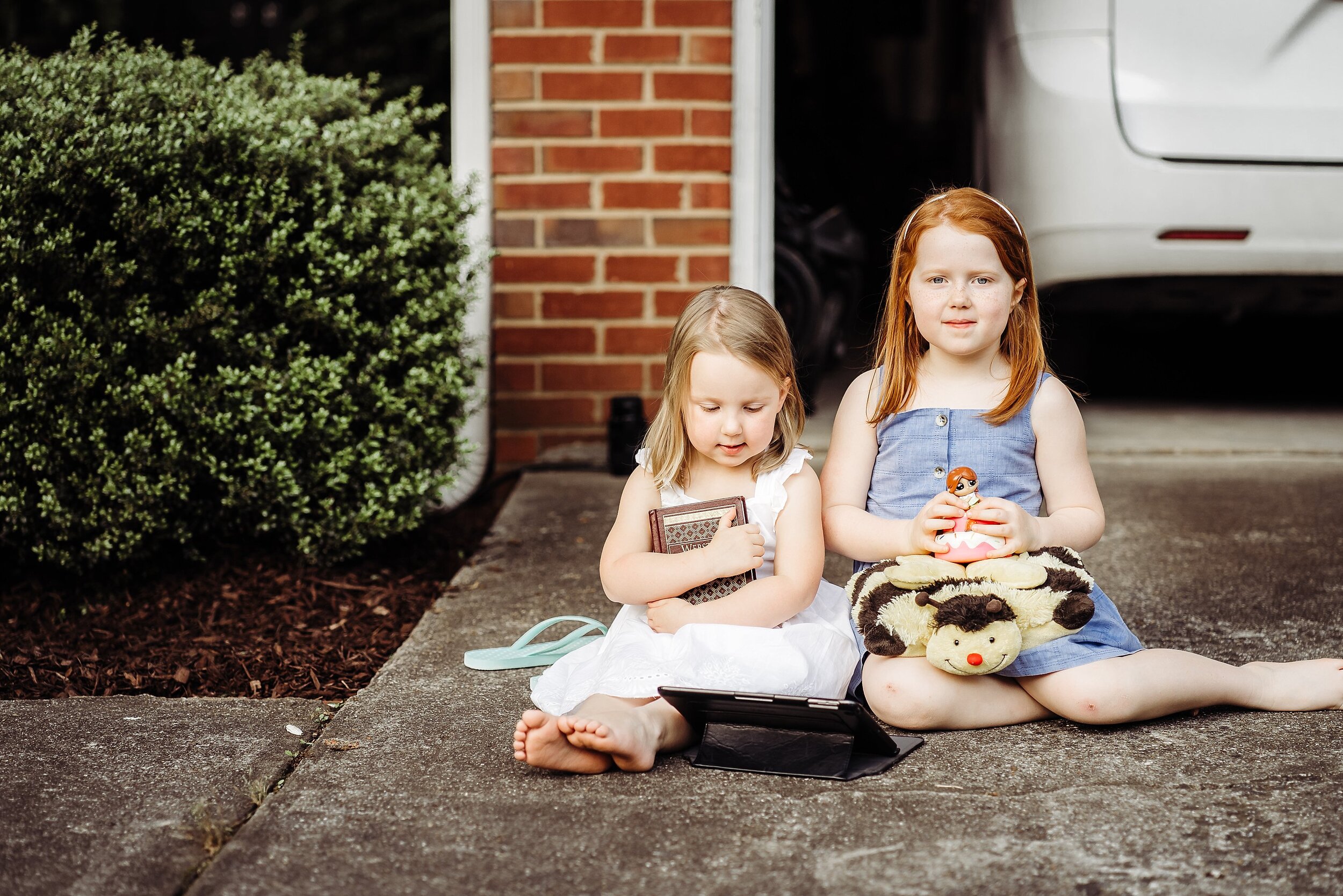 two girls sitting in driveway