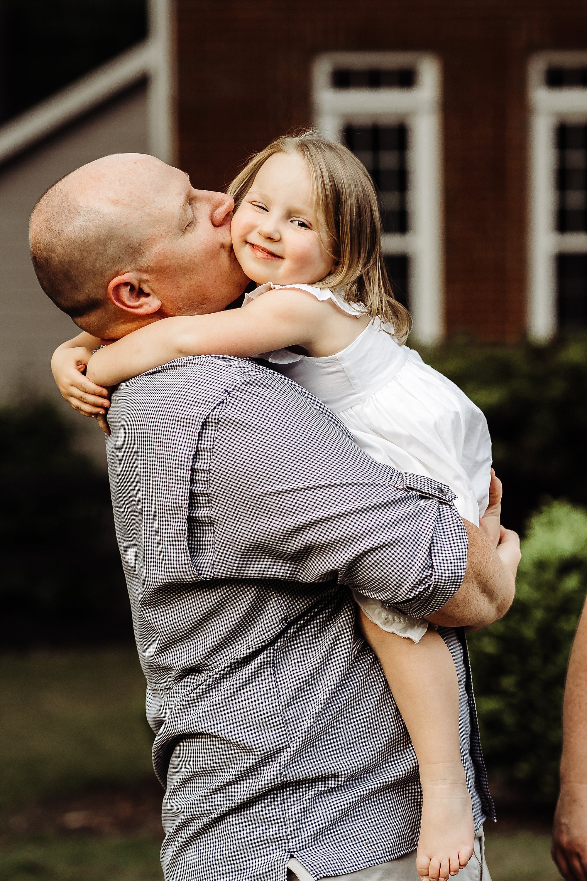 dad kissing little girl