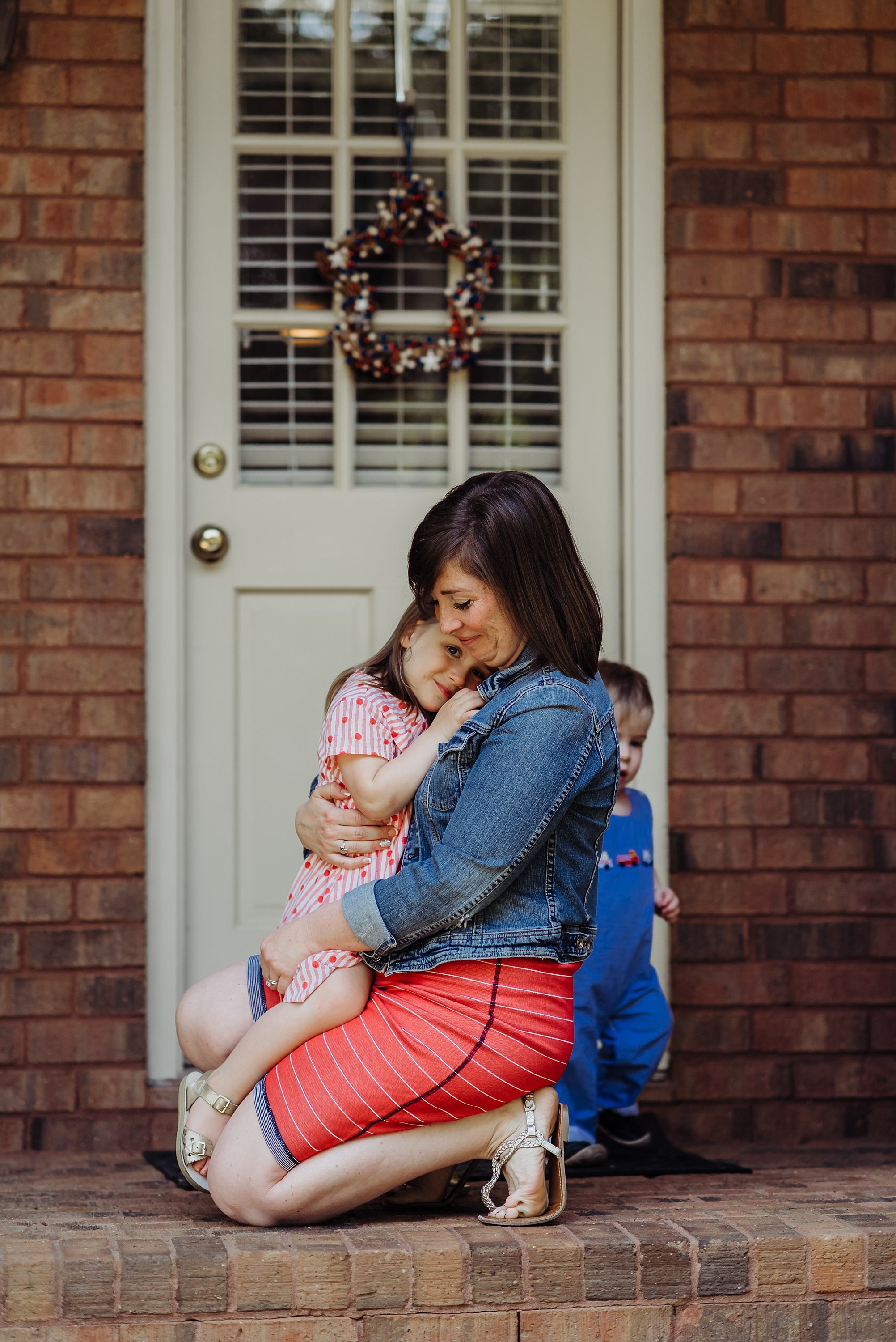 mom and daughter snuggling on porch