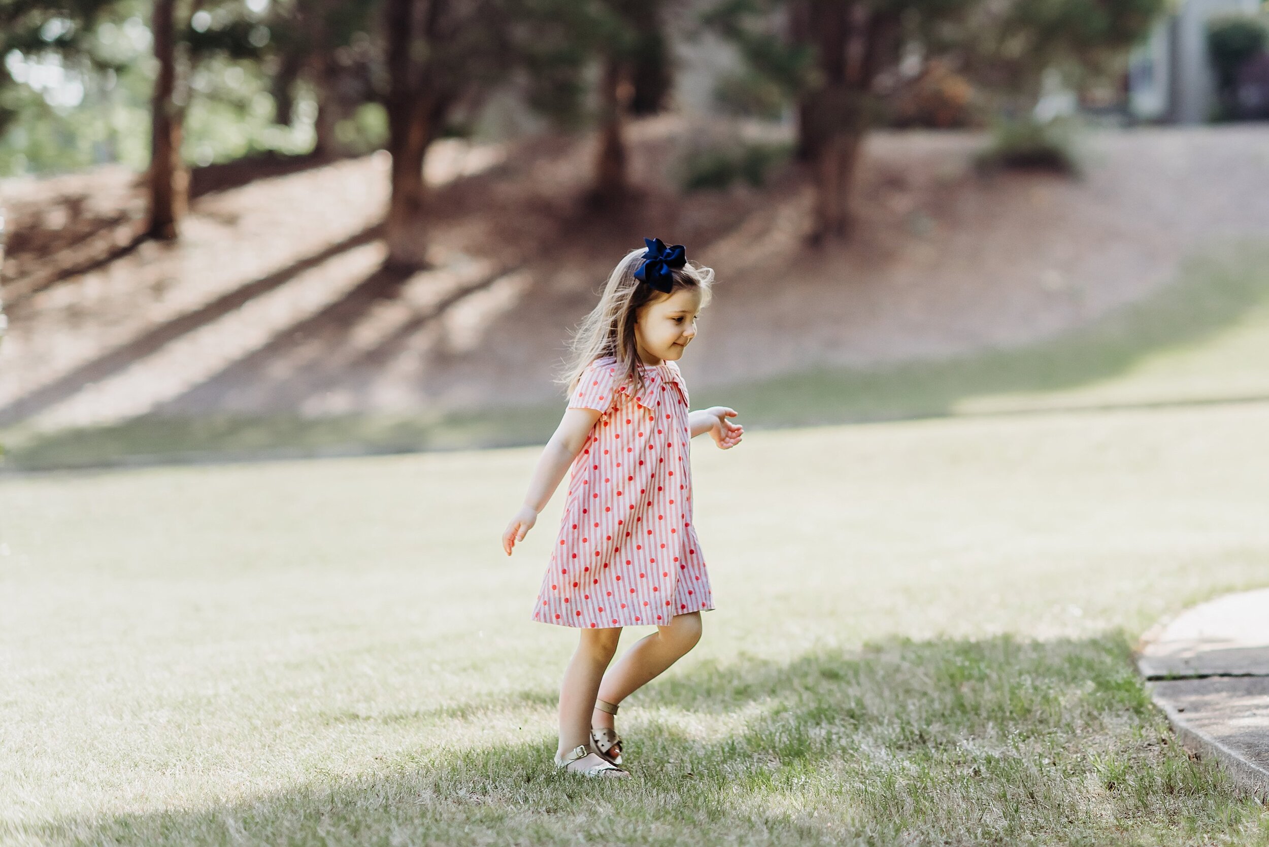 toddler girl running through grass